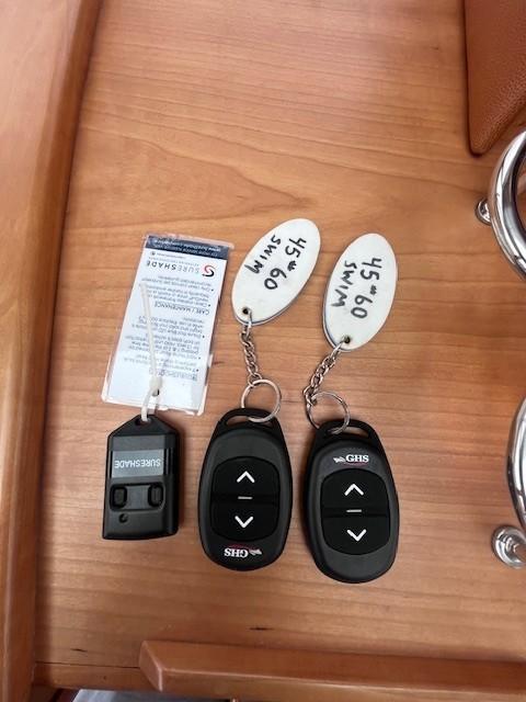Remote controls and key tags on a wooden surface for a 2021 Sabre 45 Salon Express.