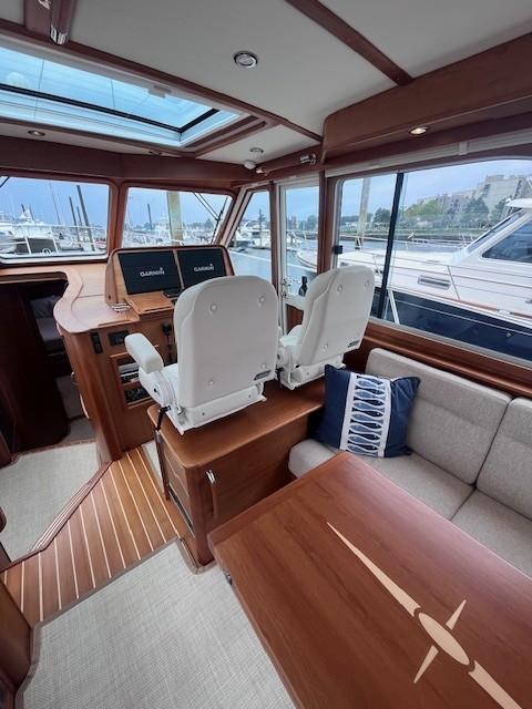 Interior of 2021 Sabre 45 Salon Express yacht with helm and seating area.