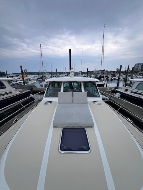 2021 Sabre 45 Salon Express yacht docked at marina under cloudy sky.