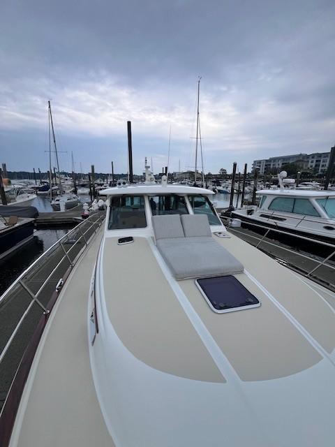 2021 Sabre 45 Salon Express yacht docked at marina under cloudy sky.