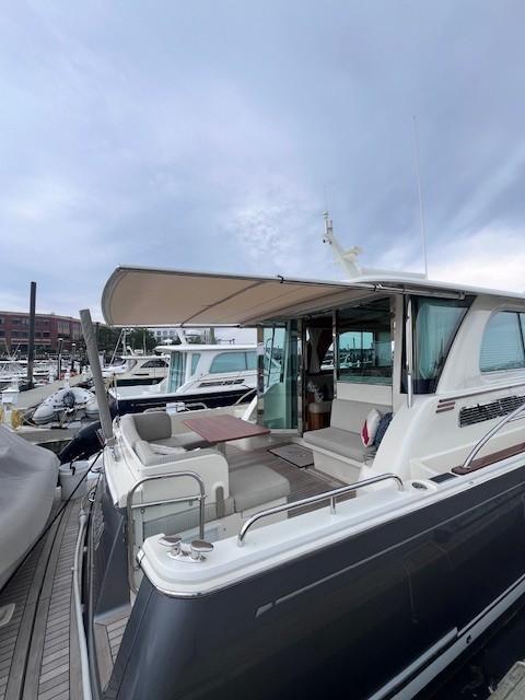 2021 Sabre 45 Salon Express yacht docked at marina, showcasing sleek design and spacious deck.
