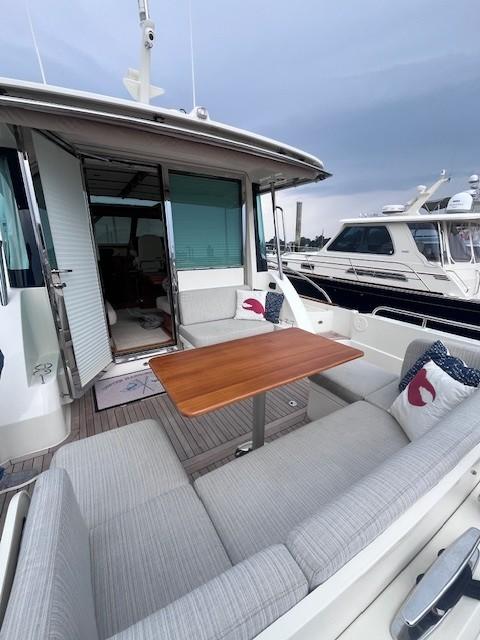 2021 Sabre 45 Salon Express yacht with outdoor seating and wooden table.