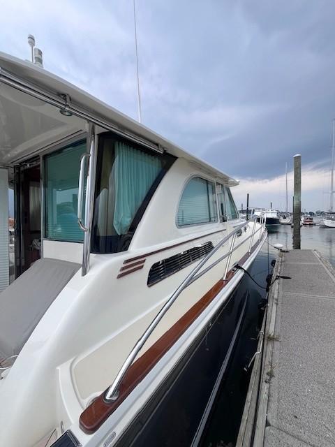 2021 Sabre 45 Salon Express yacht docked at marina under cloudy sky.