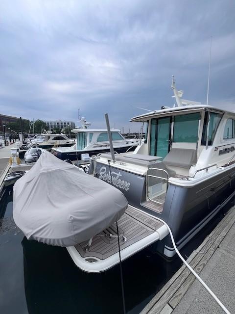 2021 Sabre 45 Salon Express yacht docked at marina under cloudy sky.