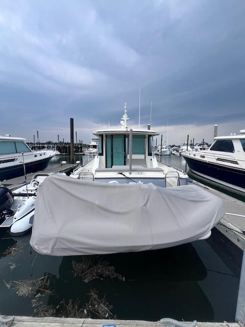 2021 Sabre 45 Salon Express yacht docked at marina under cloudy sky.