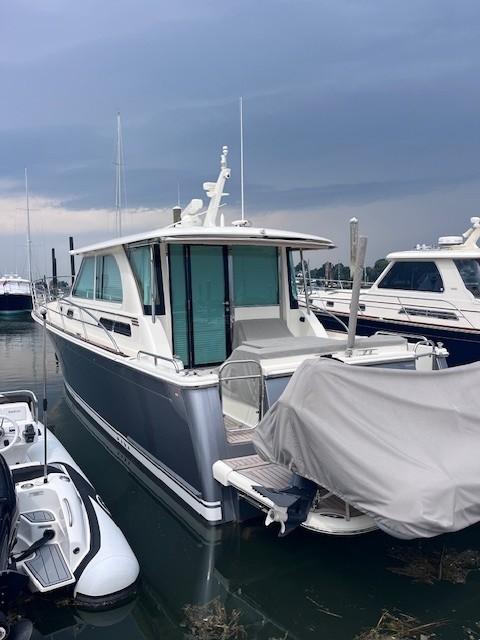 2021 Sabre 45 Salon Express yacht docked in a marina under cloudy skies.