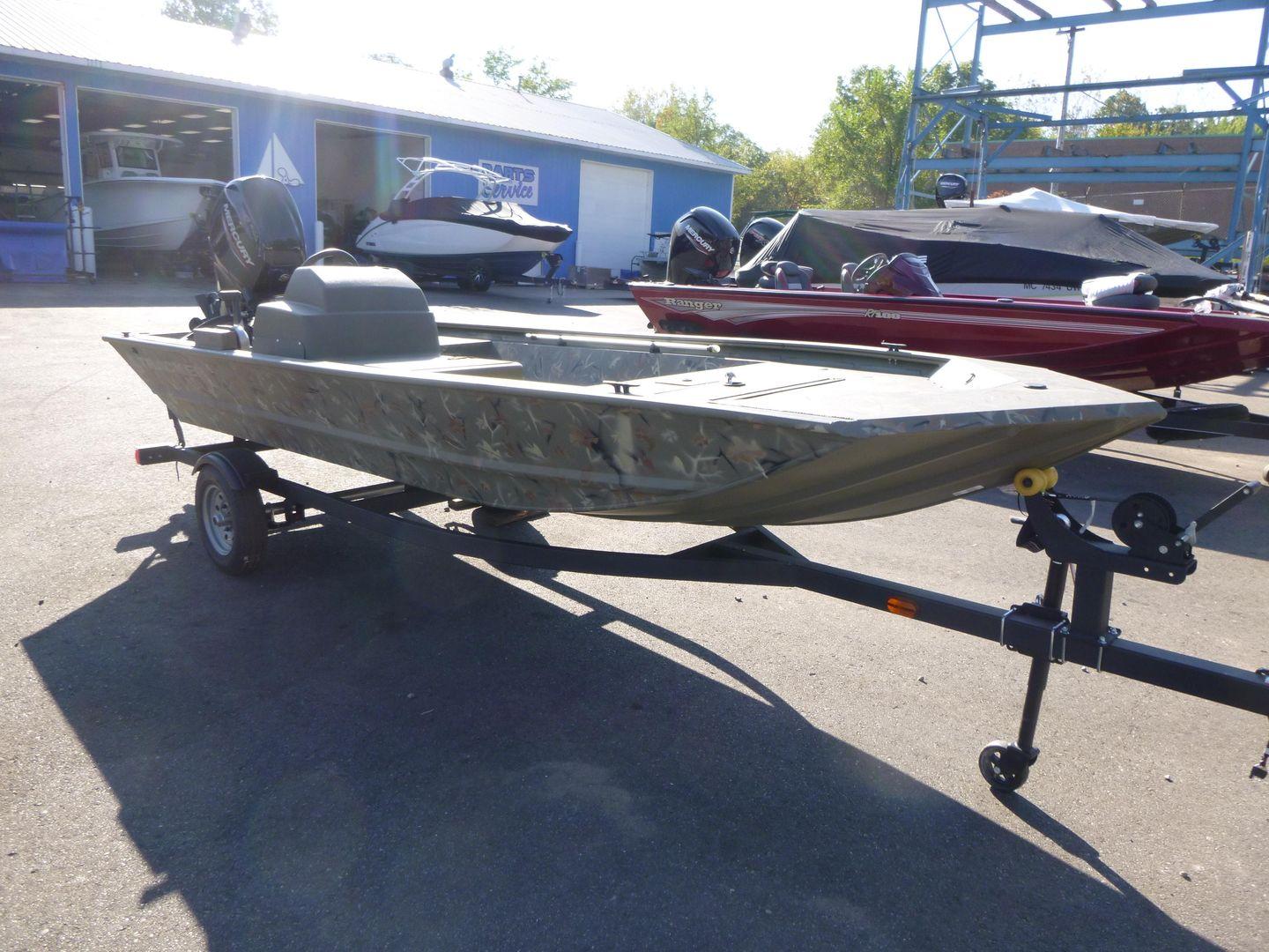 2024 Tracker Grizzly 1648 SC boat on trailer in outdoor showroom.