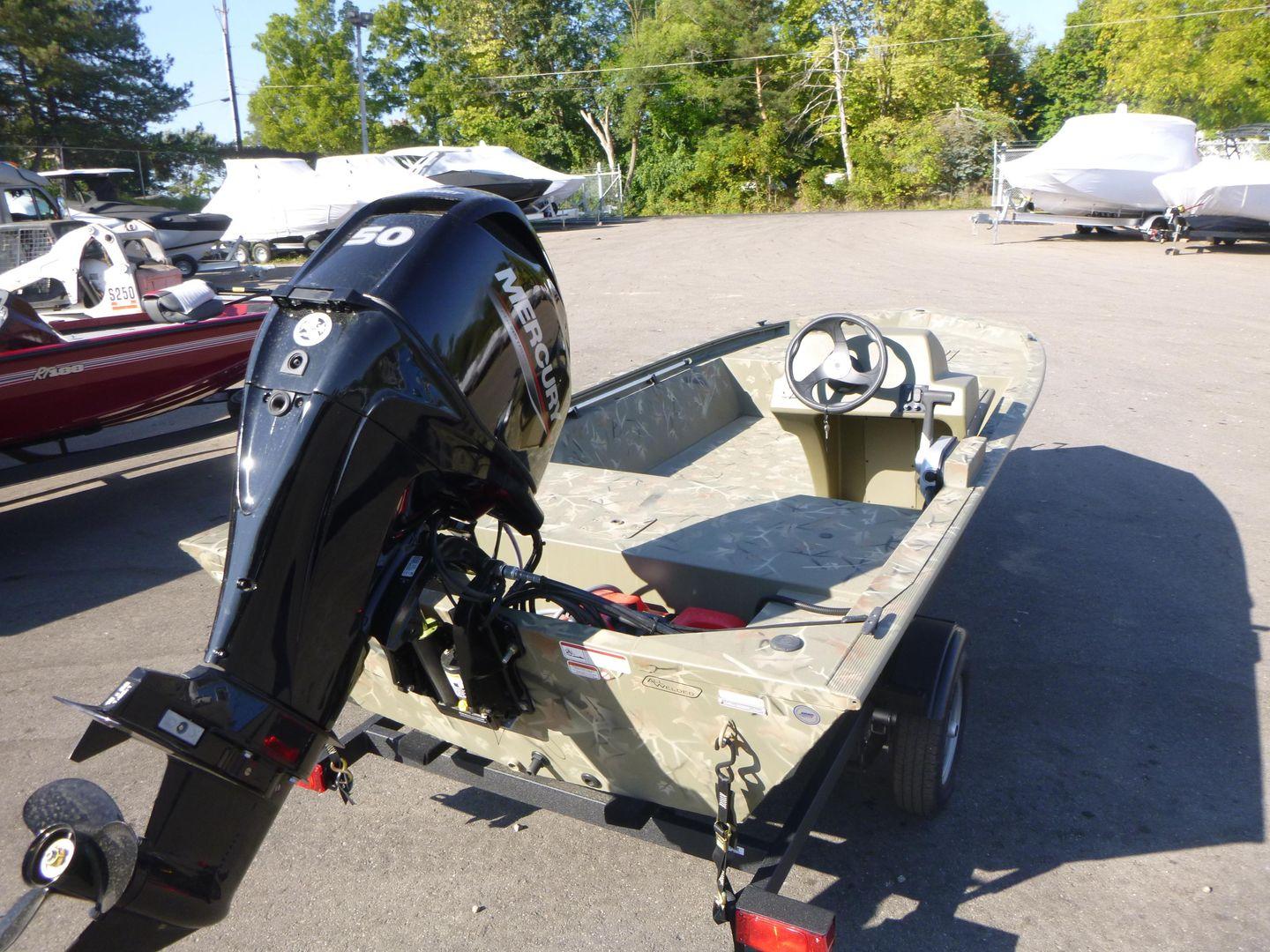2024 Tracker Grizzly 1648 SC boat with Mercury outboard motor in a parking lot.