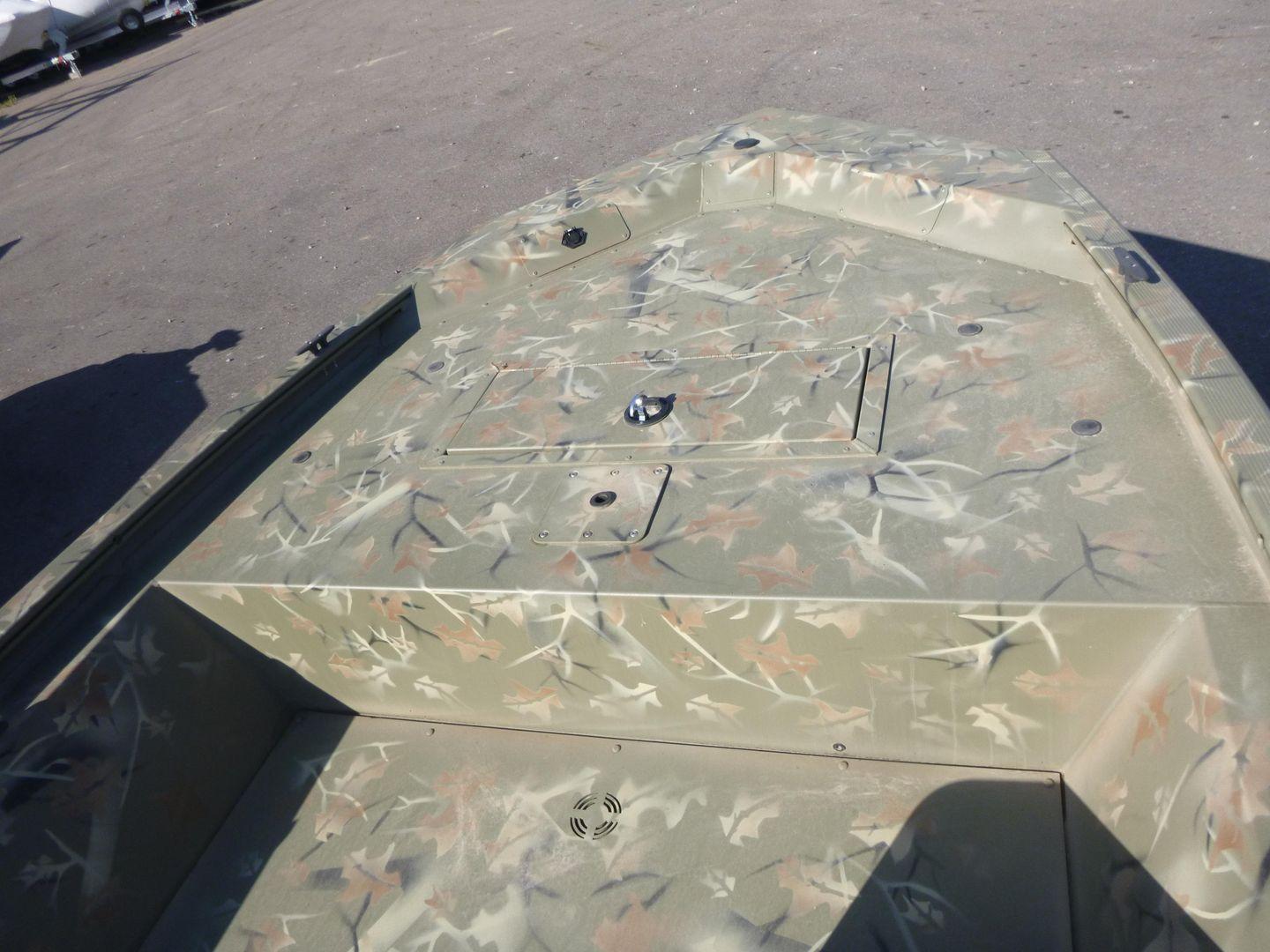 2024 Tracker Grizzly 1648 SC boat with camouflage design, parked on a gravel surface.