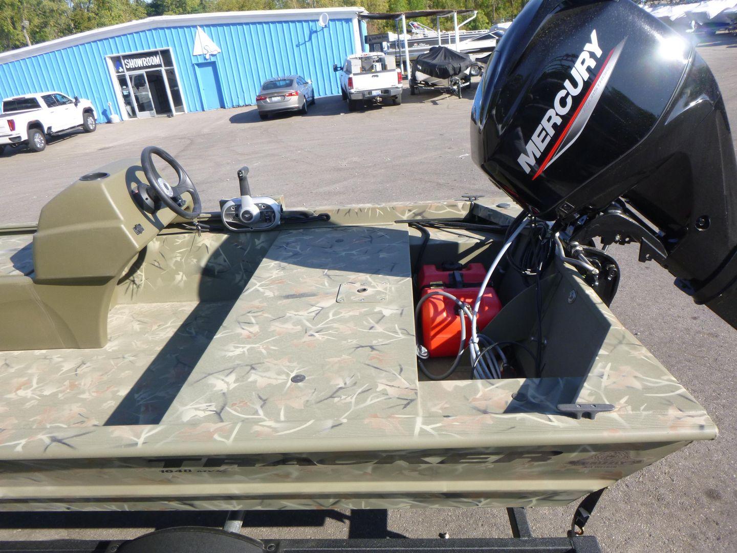 2024 Tracker Grizzly 1648 SC boat with Mercury outboard motor in dealership lot.