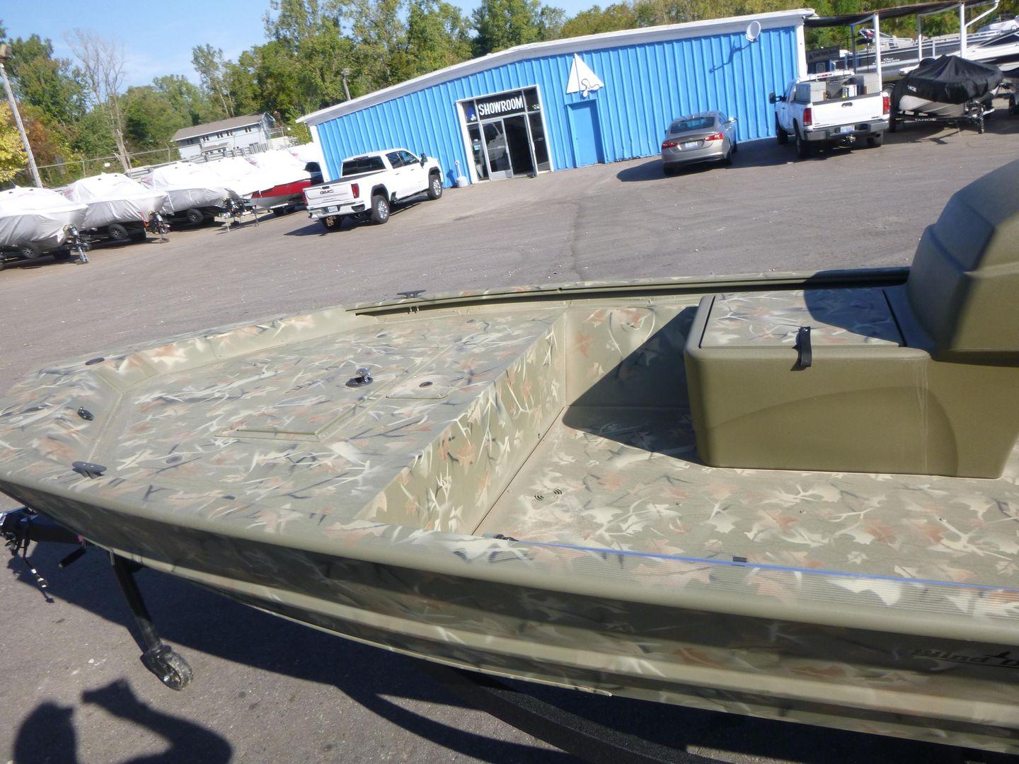 2024 Tracker Grizzly 1648 SC boat in a dealership lot, showcasing camouflage design.