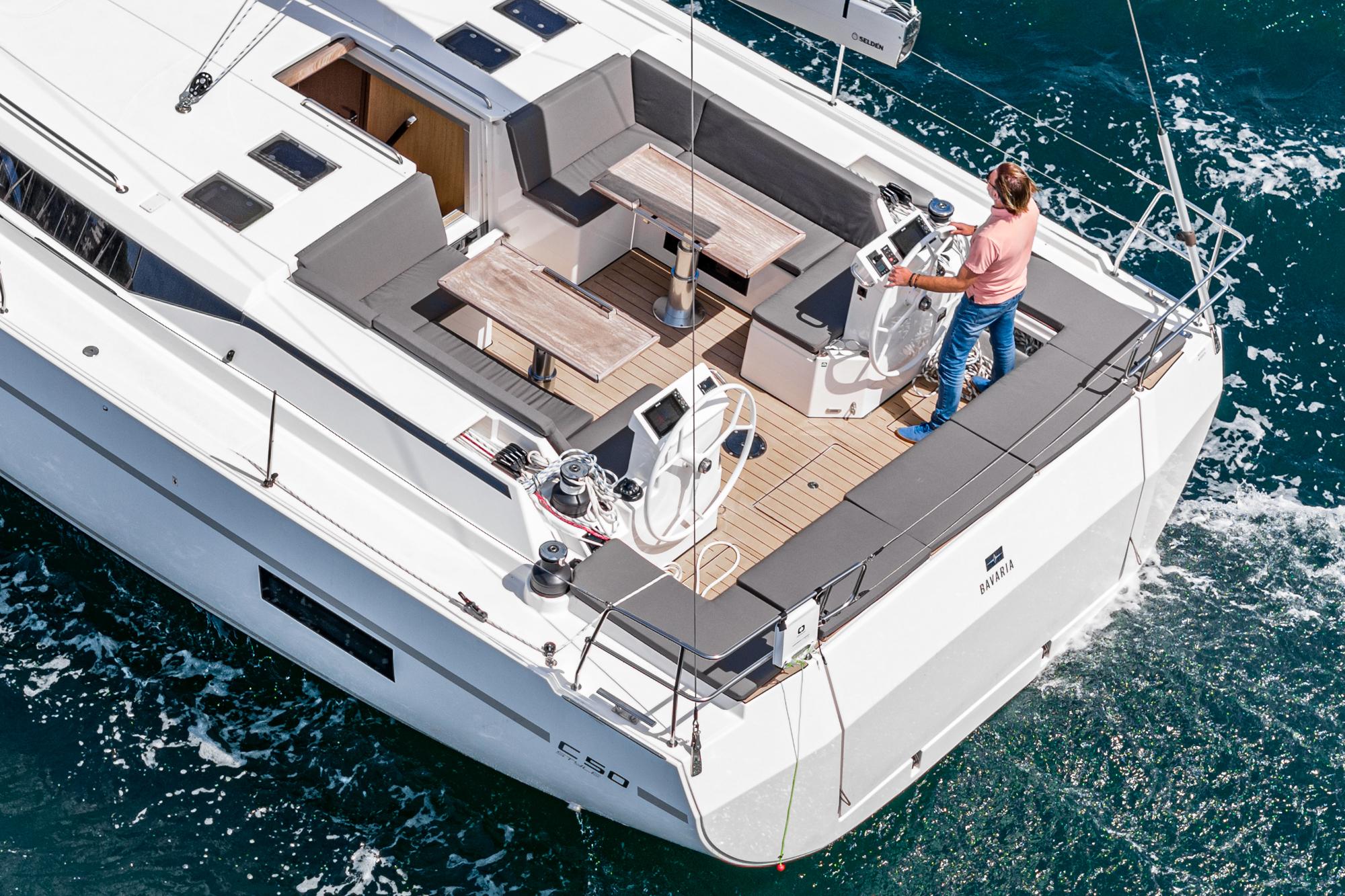 Bavaria-C50 2024-This could be yours CA-US-2024 Bavaria C50 yacht sailing with person at helm, featuring spacious deck and seating area.-9654457 | Thumbnail
