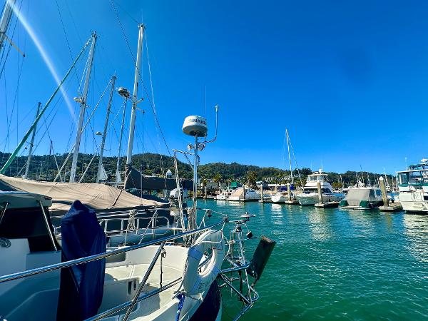 Sailboats docked in a marina under clear blue skies, featuring a 1996 Valiant 39.