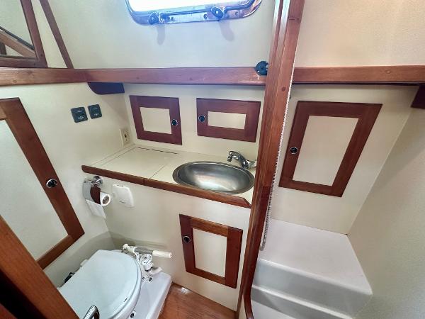 1996 Valiant 39 yacht bathroom with sink, toilet, and wooden accents.