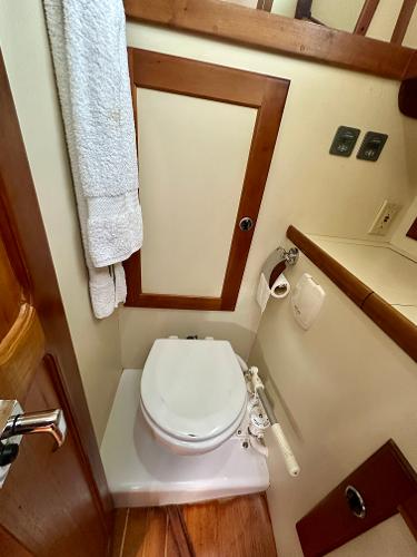 Compact bathroom in a 1996 Valiant 39 yacht with wooden accents and white fixtures.