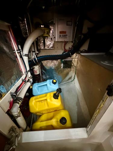 Engine compartment of a 1996 Valiant 39 with fuel containers and electrical components.