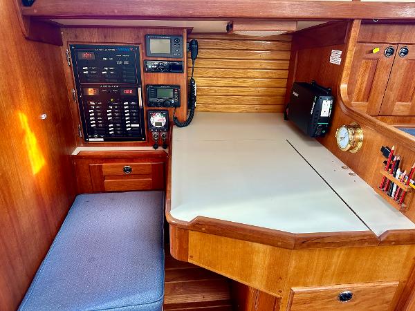 Navigation station in a 1996 Valiant 39 sailboat with control panel and seating.