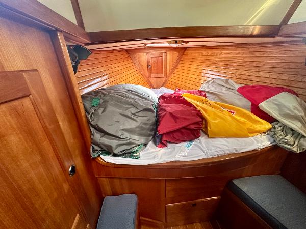 Cozy cabin interior of a 1996 Valiant 39 sailboat with colorful bedding.