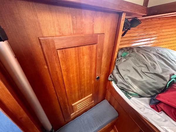 Wooden interior of a 1996 Valiant 39 boat cabin with bedding and storage.