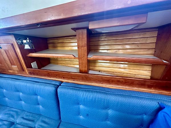 Wooden interior shelving and blue cushioned seating in a 1996 Valiant 39 boat.