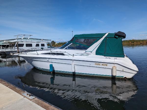 1992 Sea Ray 330 Express Cruiser docked on calm water with green canopy.