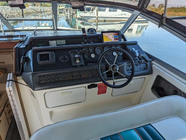 1992 Sea Ray 330 Express Cruiser helm with steering wheel and navigation instruments.