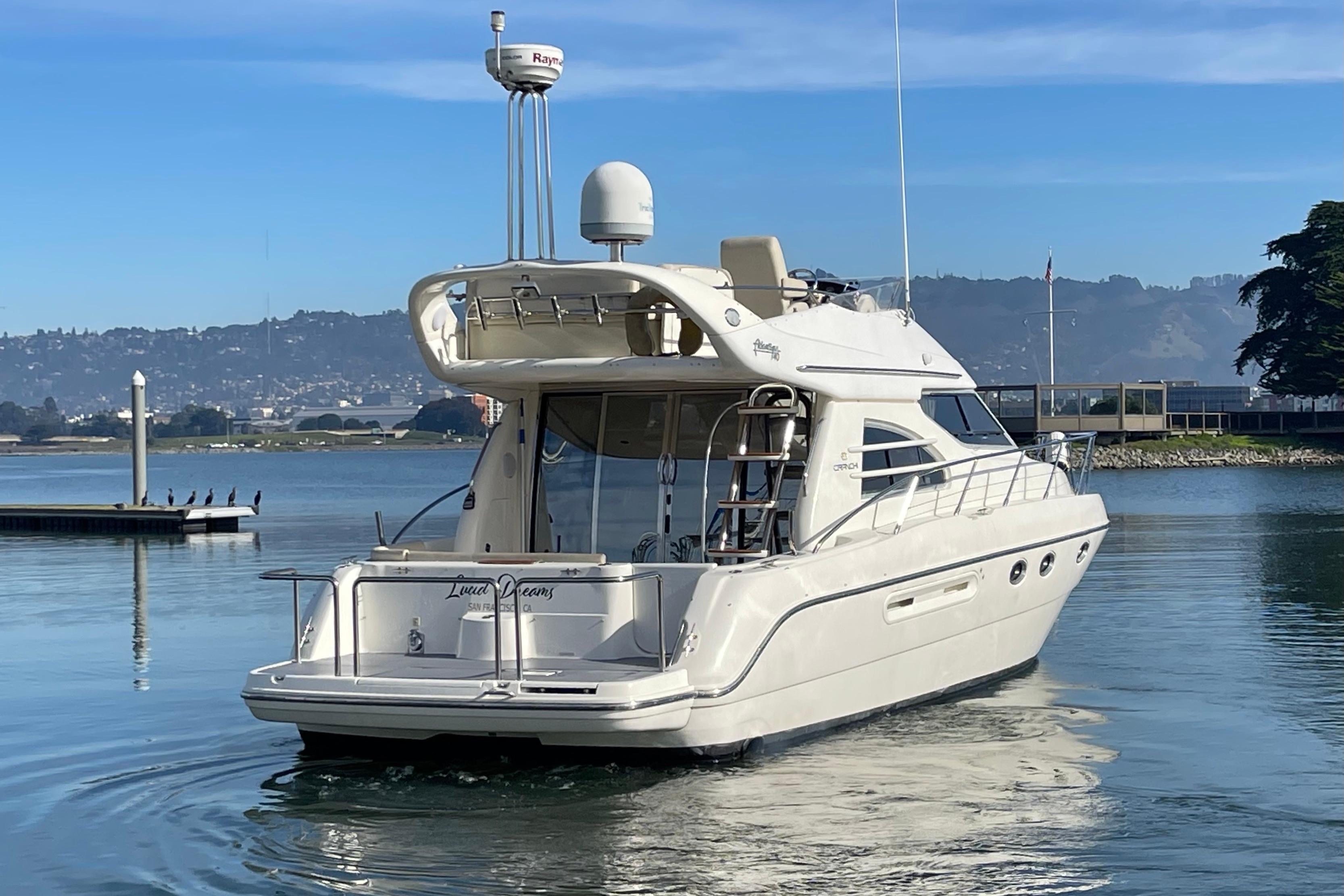 2003 Cranchi Atlantique 40 yacht on calm water with scenic background.