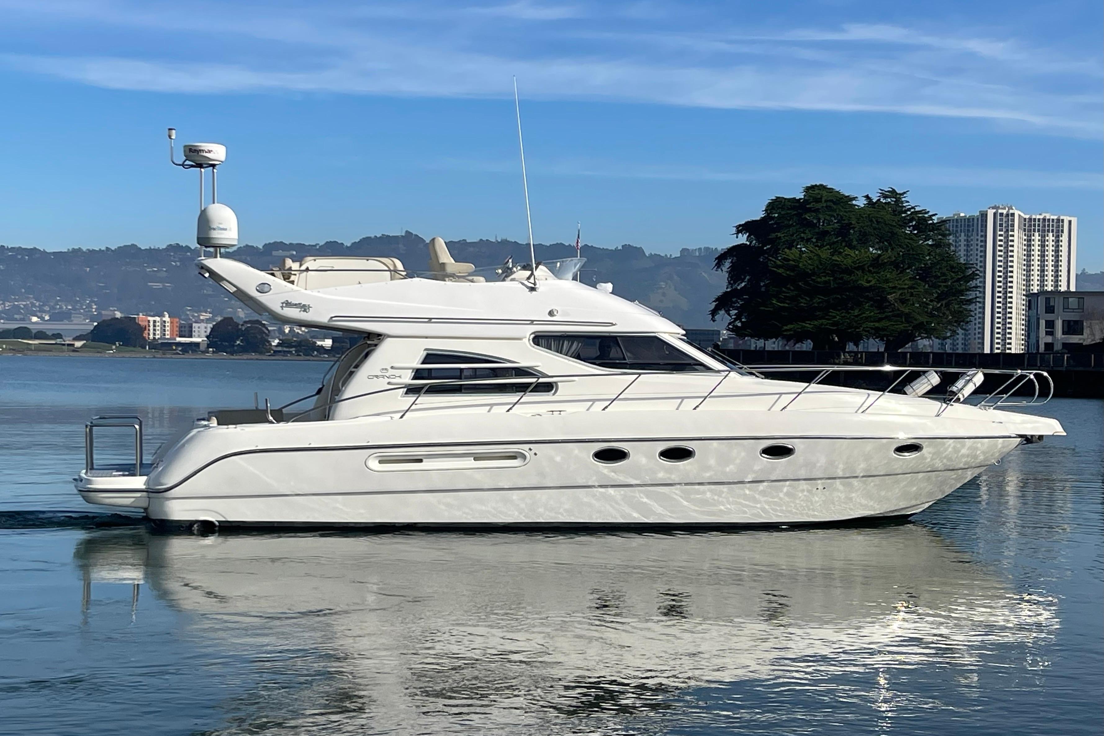 2003 Cranchi Atlantique 40 yacht on calm water, cityscape background.