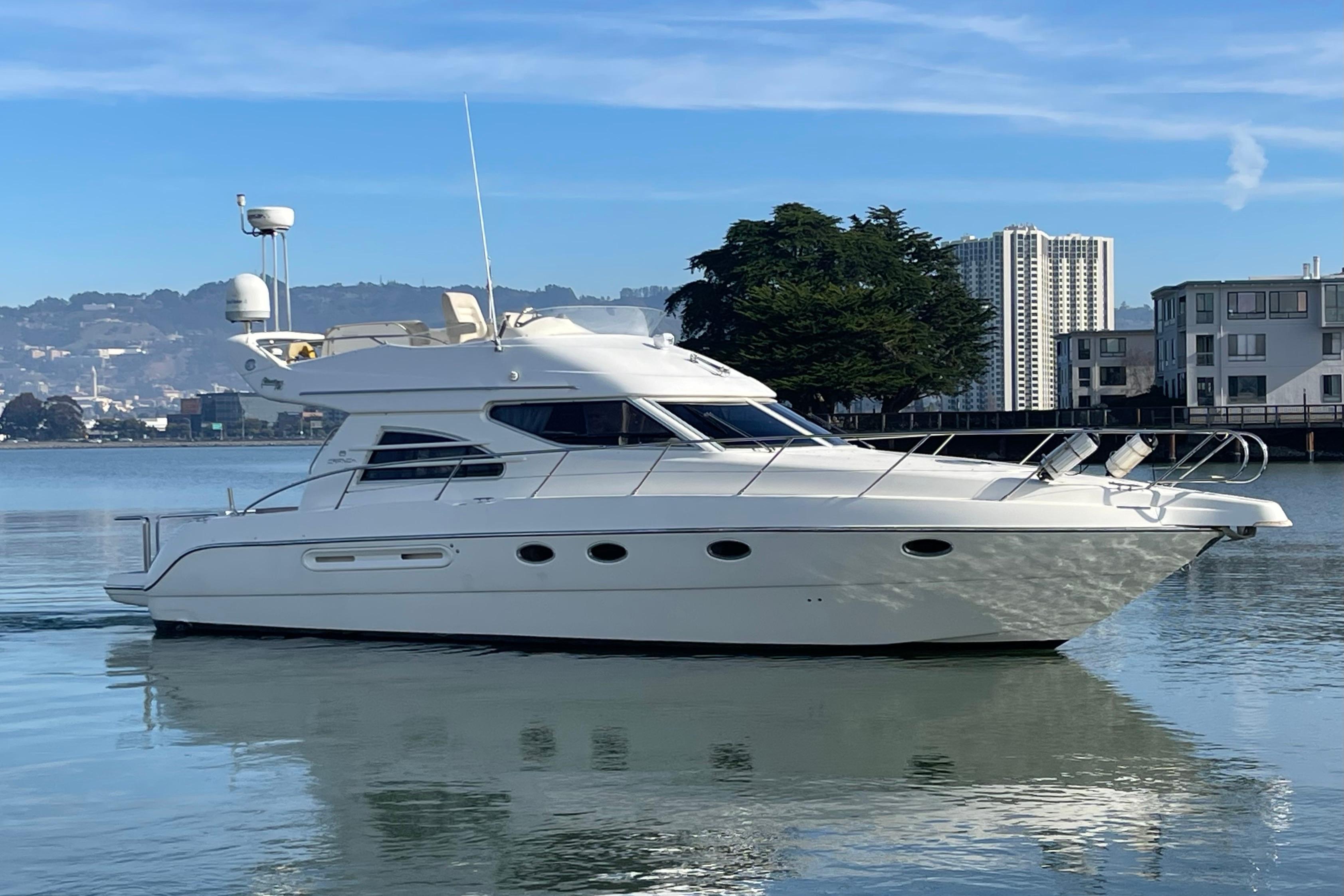 2003 Cranchi Atlantique 40 yacht on calm water with cityscape background.