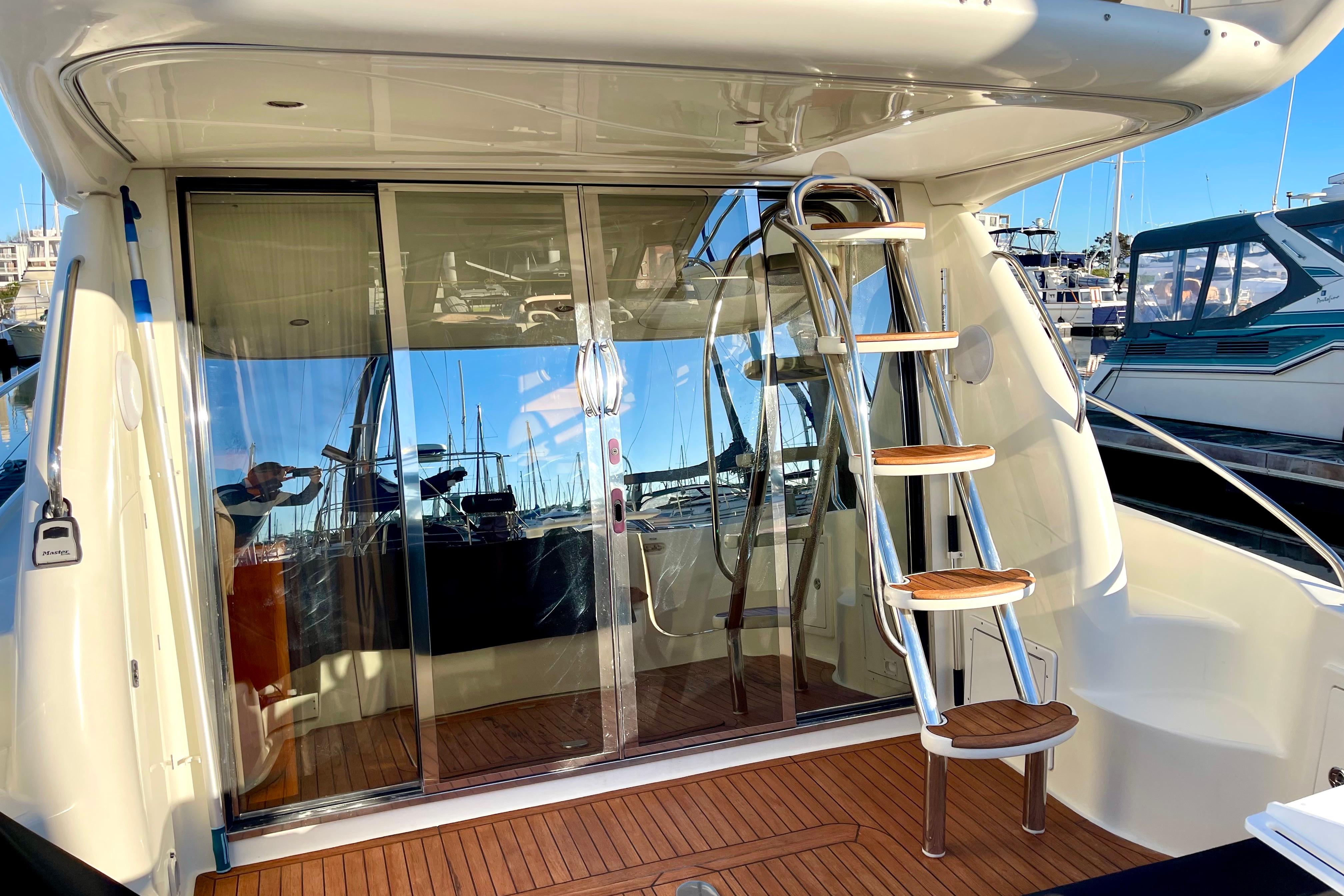 2003 Cranchi Atlantique 40 yacht with sleek design and wooden deck, docked at marina.