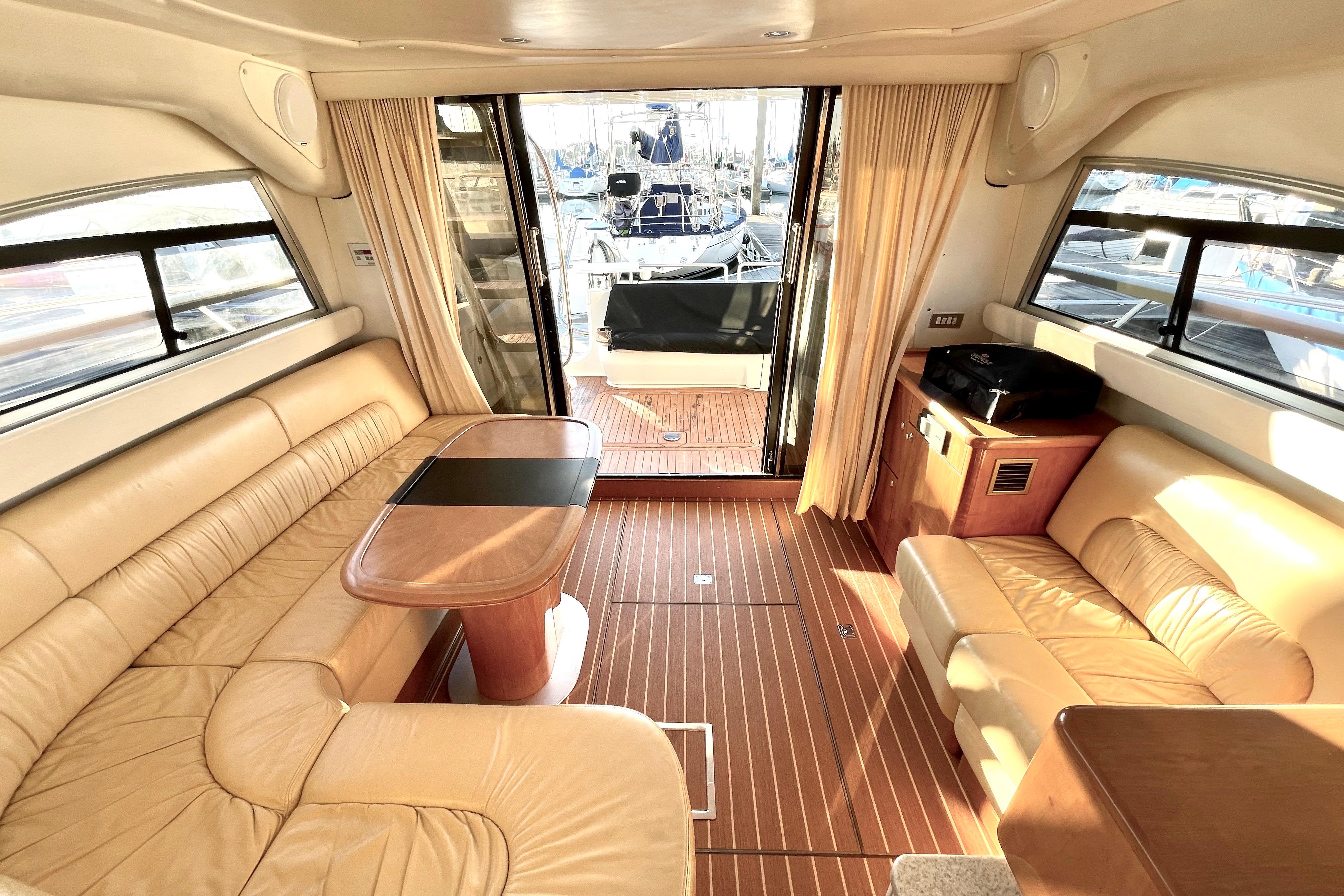 Luxurious interior of 2003 Cranchi Atlantique 40 yacht with leather seating and wooden flooring.