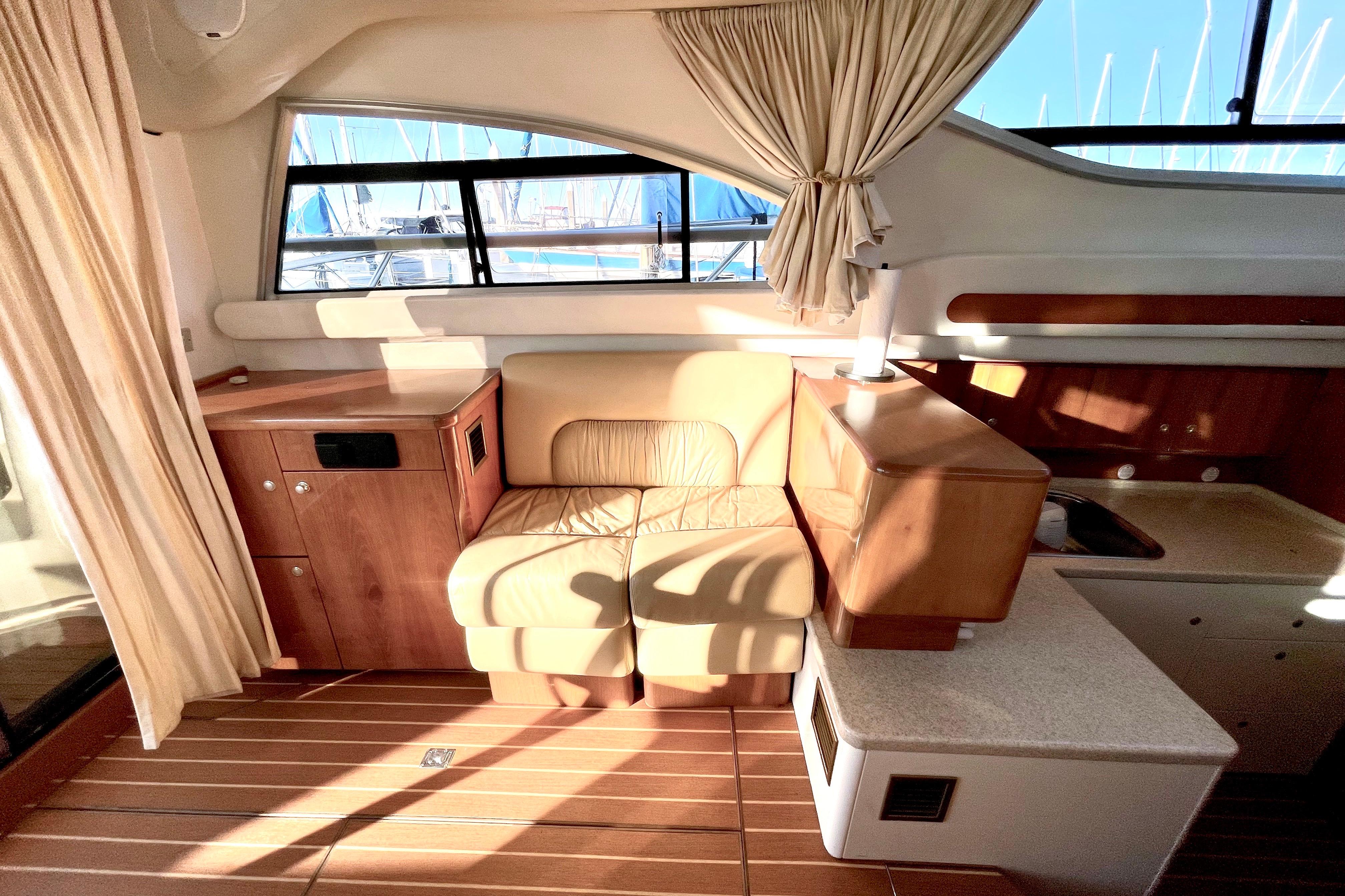 Luxurious interior of 2003 Cranchi Atlantique 40 yacht with leather seating and wooden cabinetry.