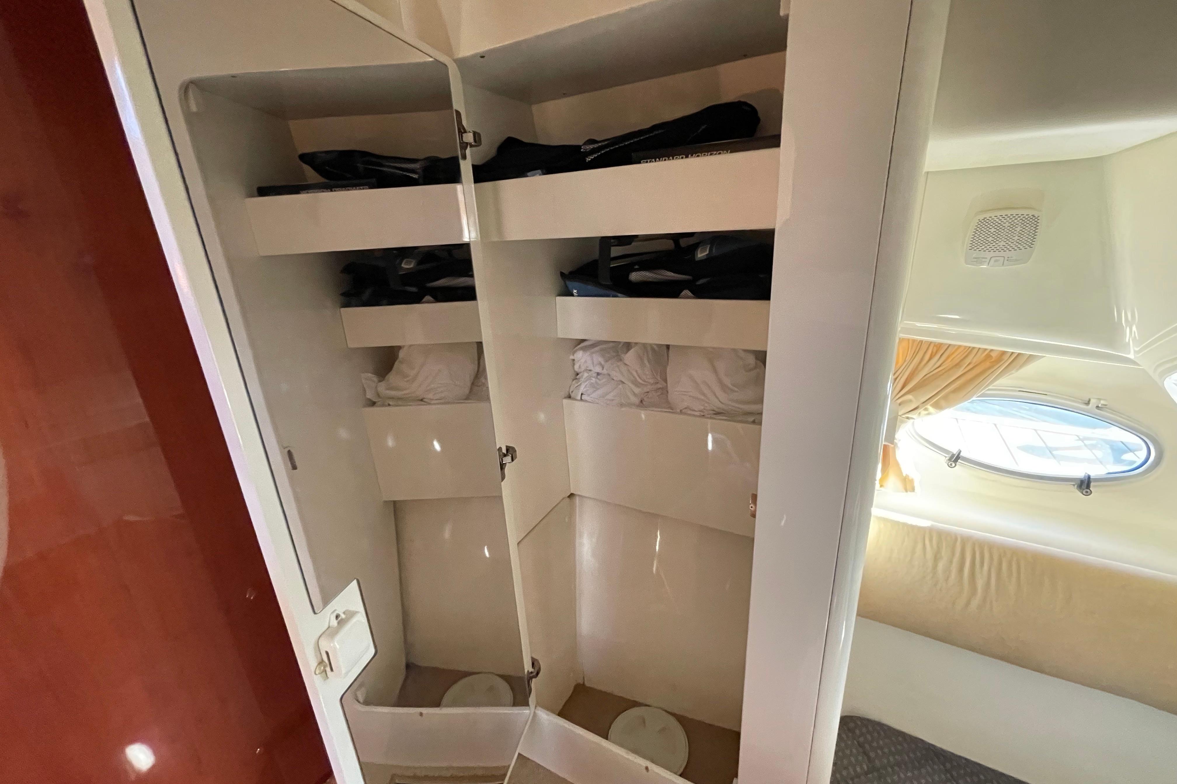 Interior storage of 2003 Cranchi Atlantique 40 yacht with shelves and porthole view.