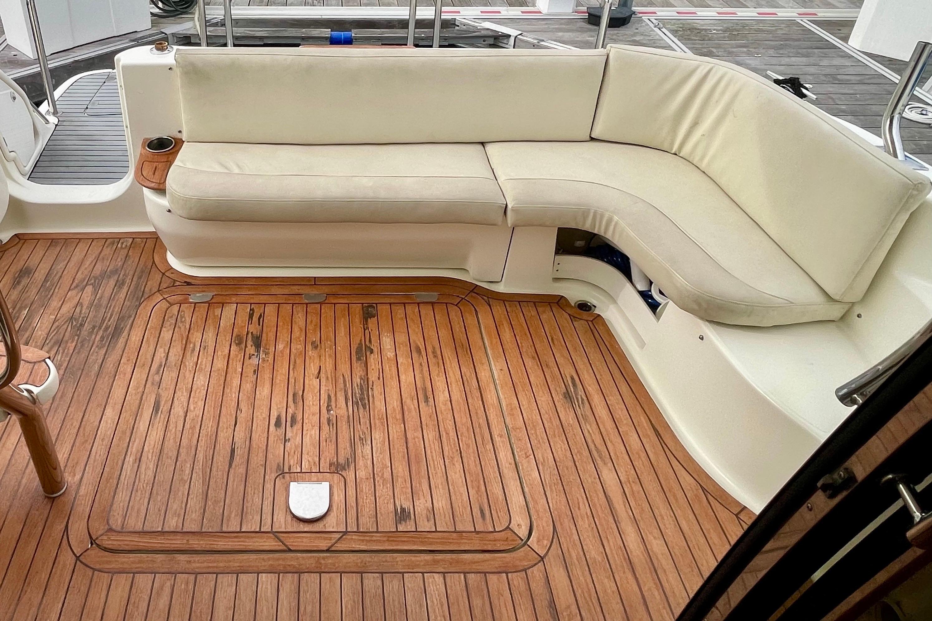 Luxurious 2003 Cranchi Atlantique 40 yacht with elegant teak deck and cushioned seating area.