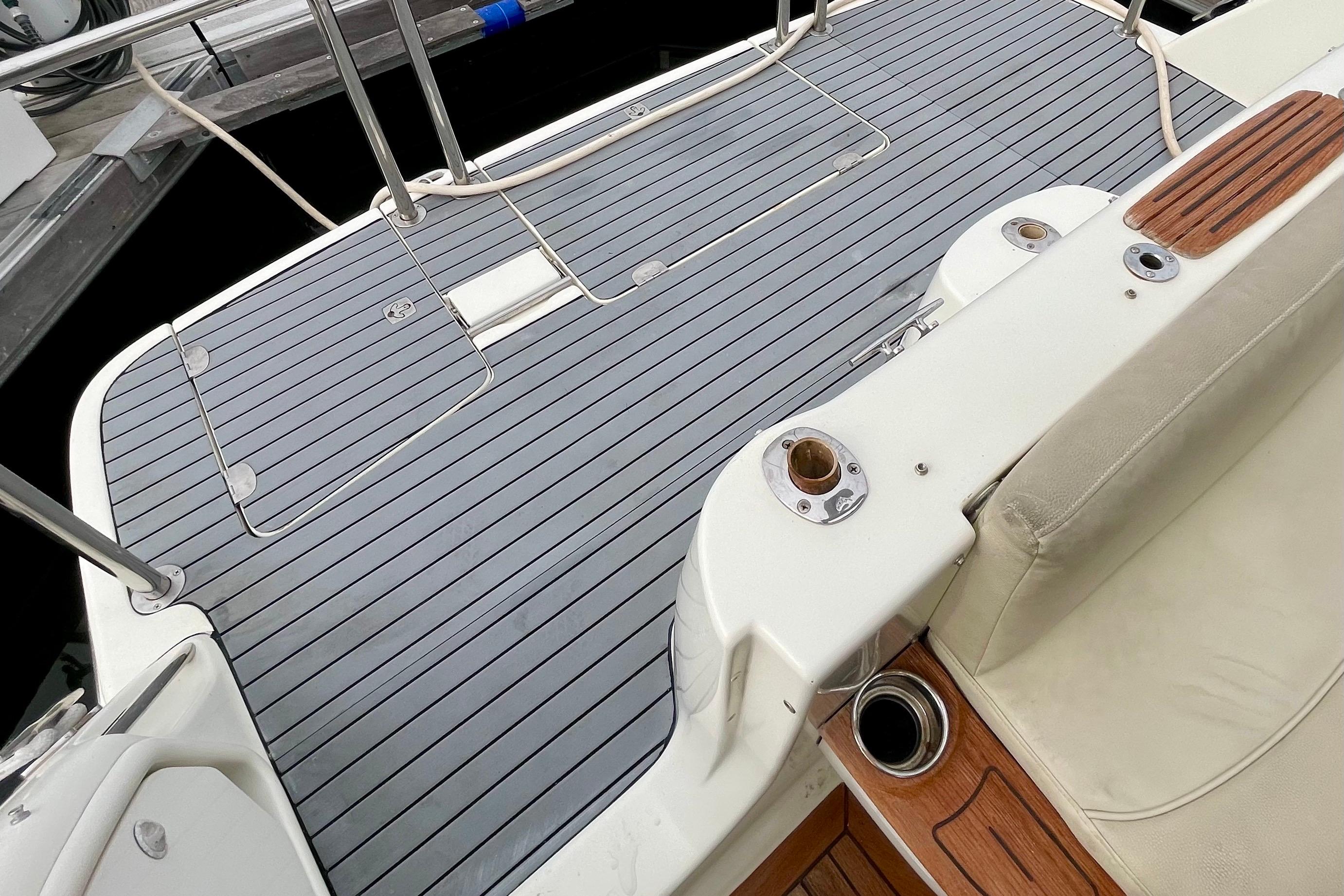 2003 Cranchi Atlantique 40 yacht deck with sleek gray flooring and white seating.