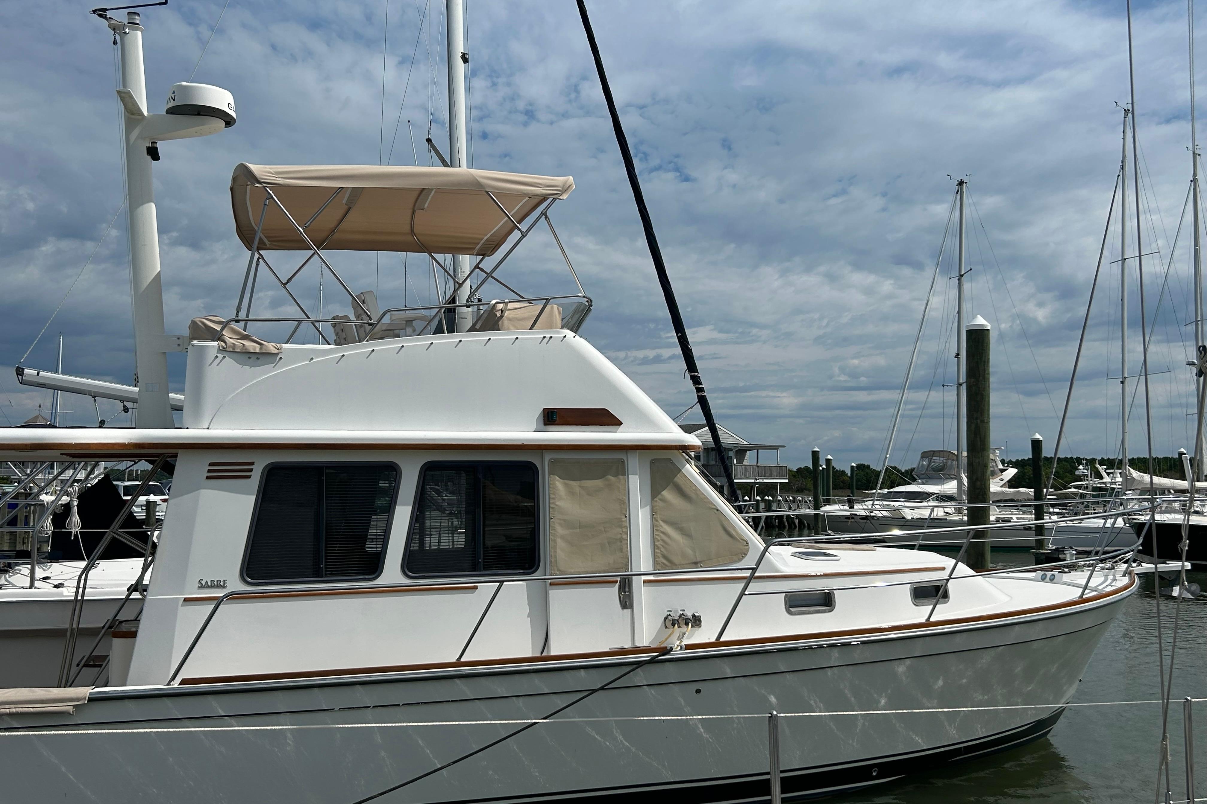 2004 Sabre 36 FB yacht docked at marina under cloudy sky.