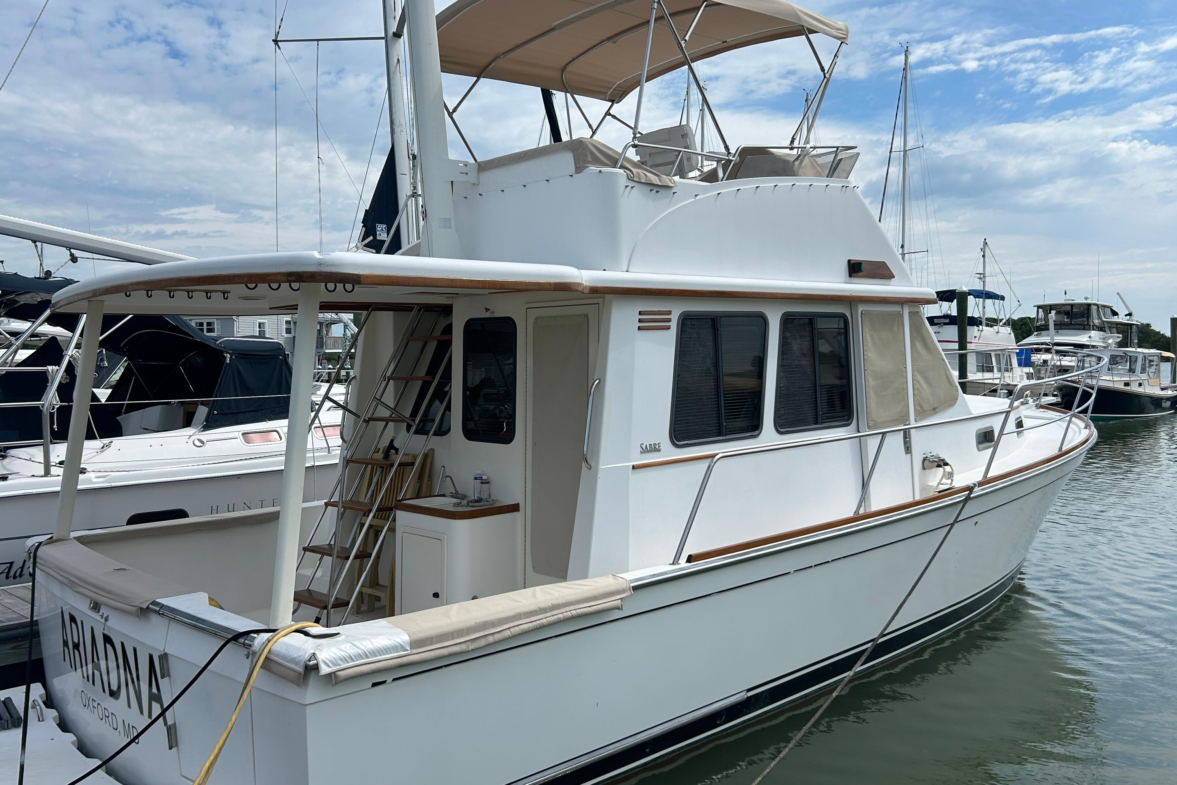 2004 Sabre 36 FB yacht docked at marina under cloudy sky.
