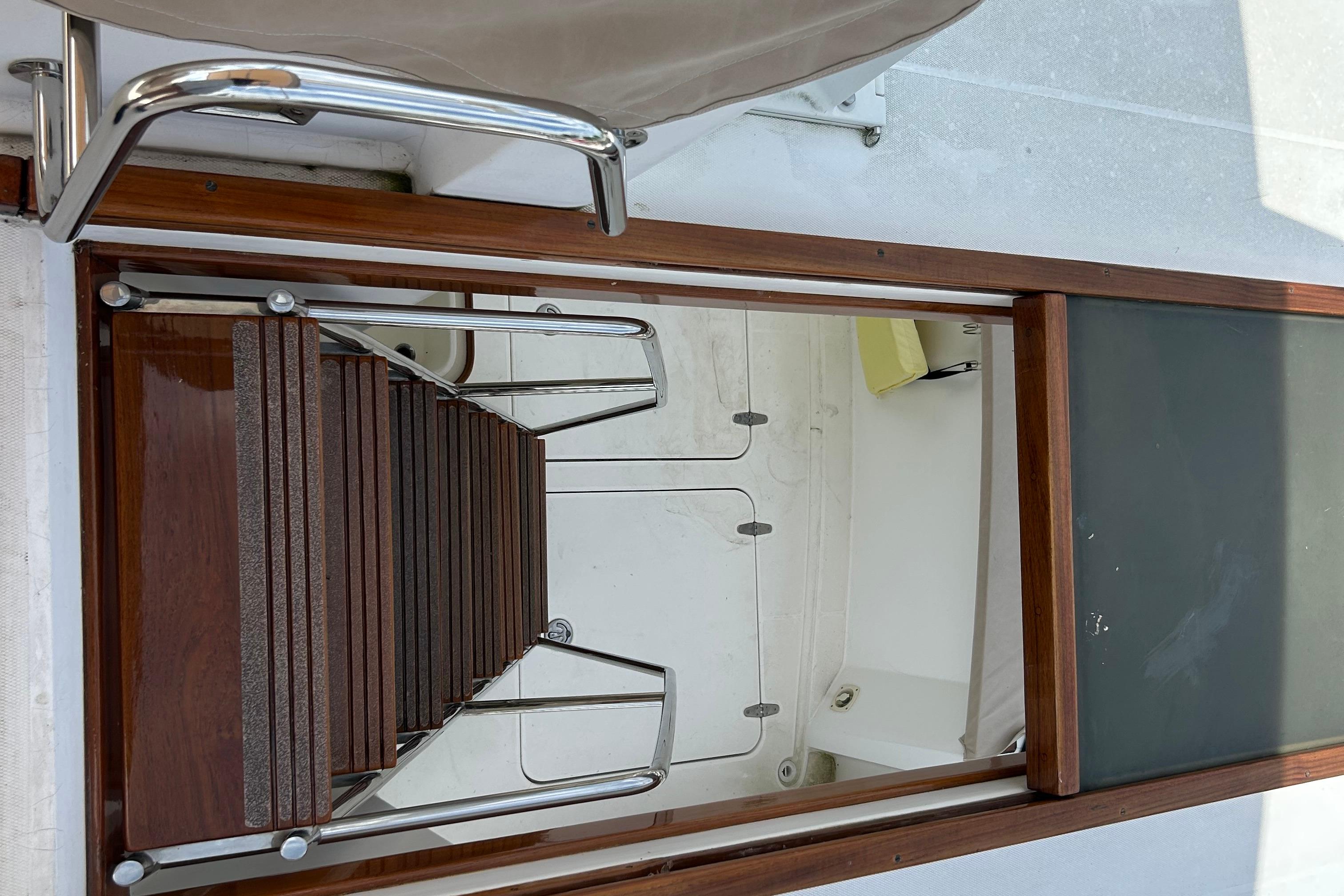 Staircase leading below deck on 2004 Sabre 36 FB yacht, featuring wooden and metal design.