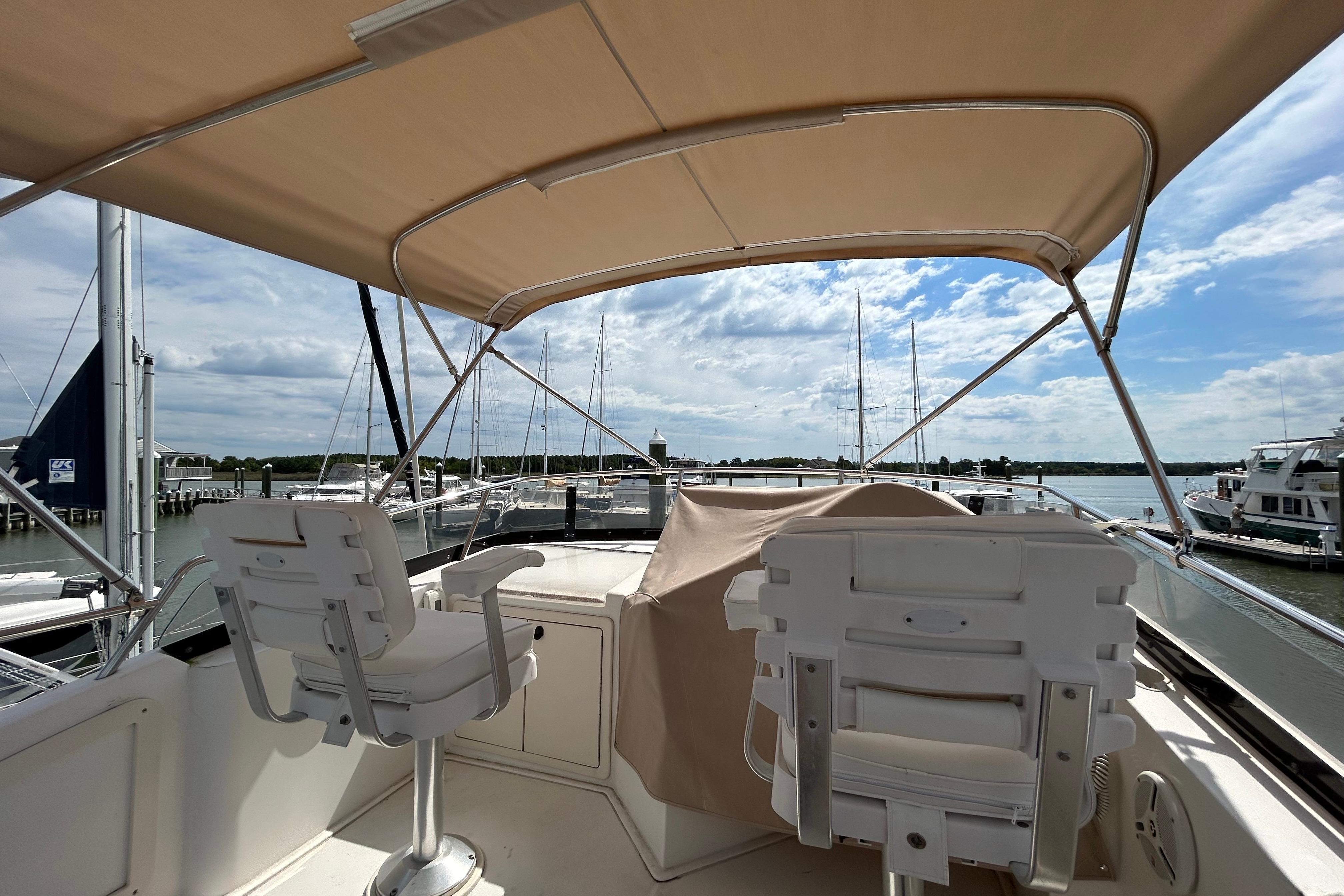 Flybridge of 2004 Sabre 36 FB yacht with seating, overlooking marina and sky.