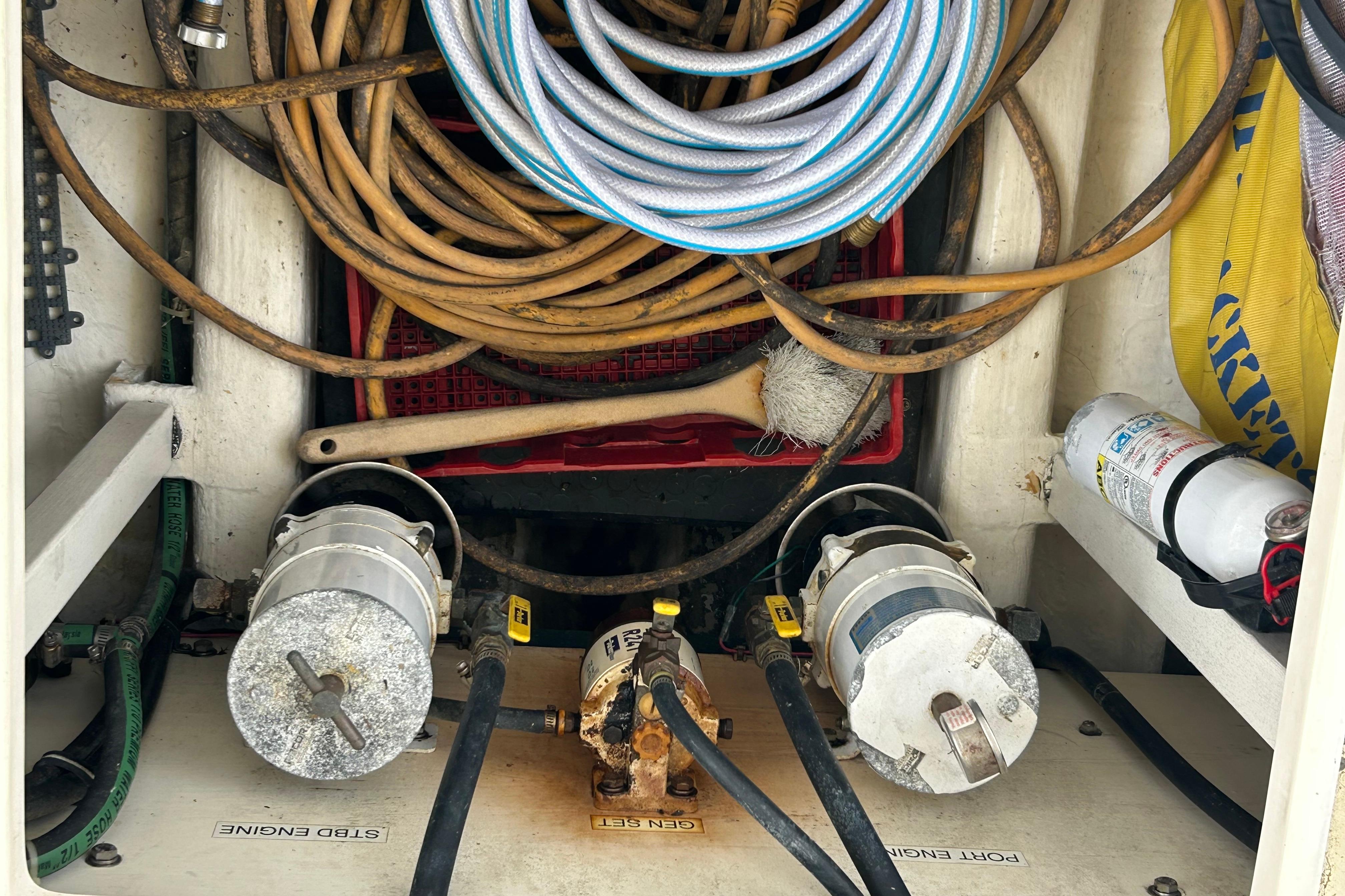Engine compartment of 2004 Sabre 36 FB with hoses, fire extinguisher, and maintenance tools.