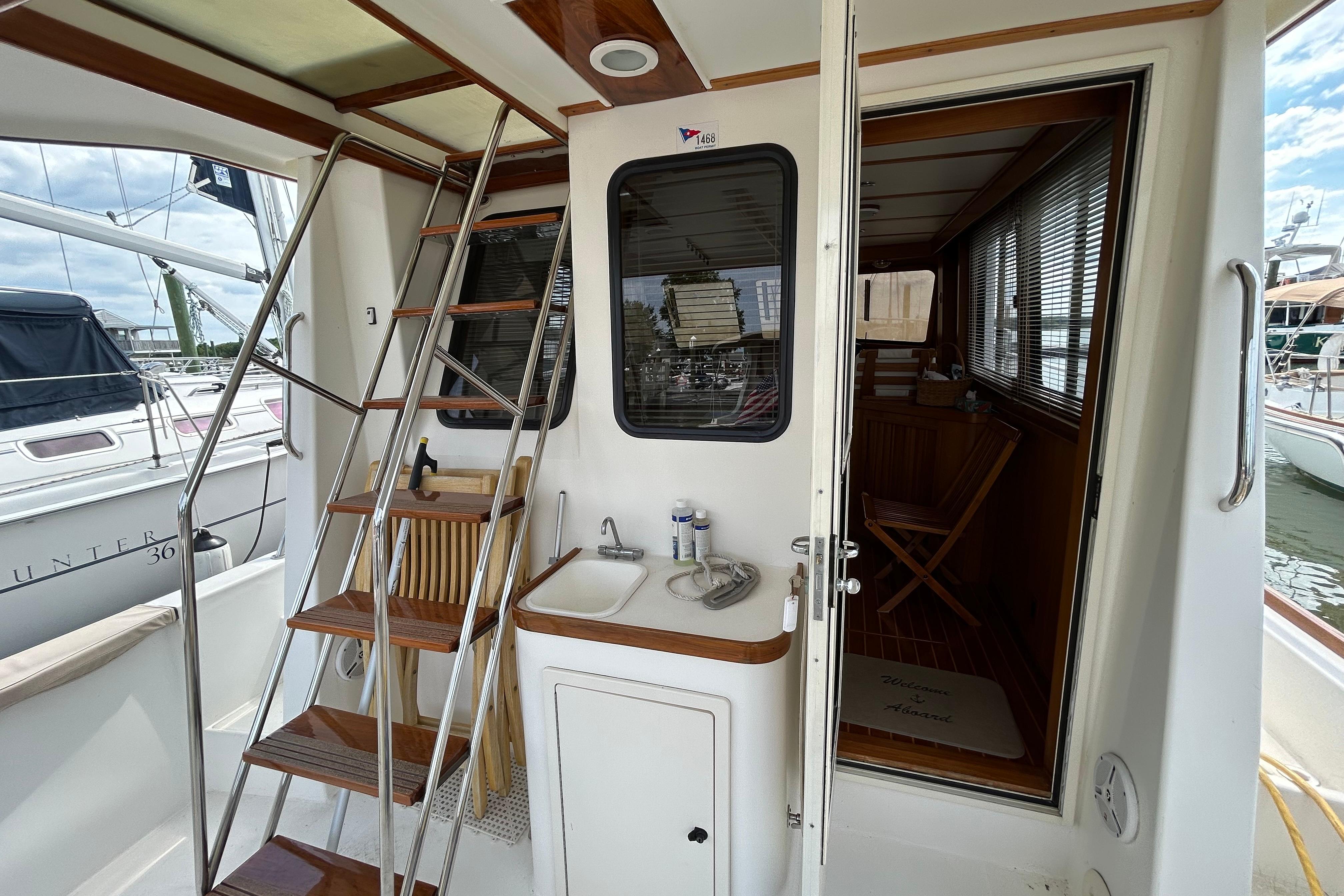2004 Sabre 36 FB yacht interior with ladder, sink, and wooden accents.