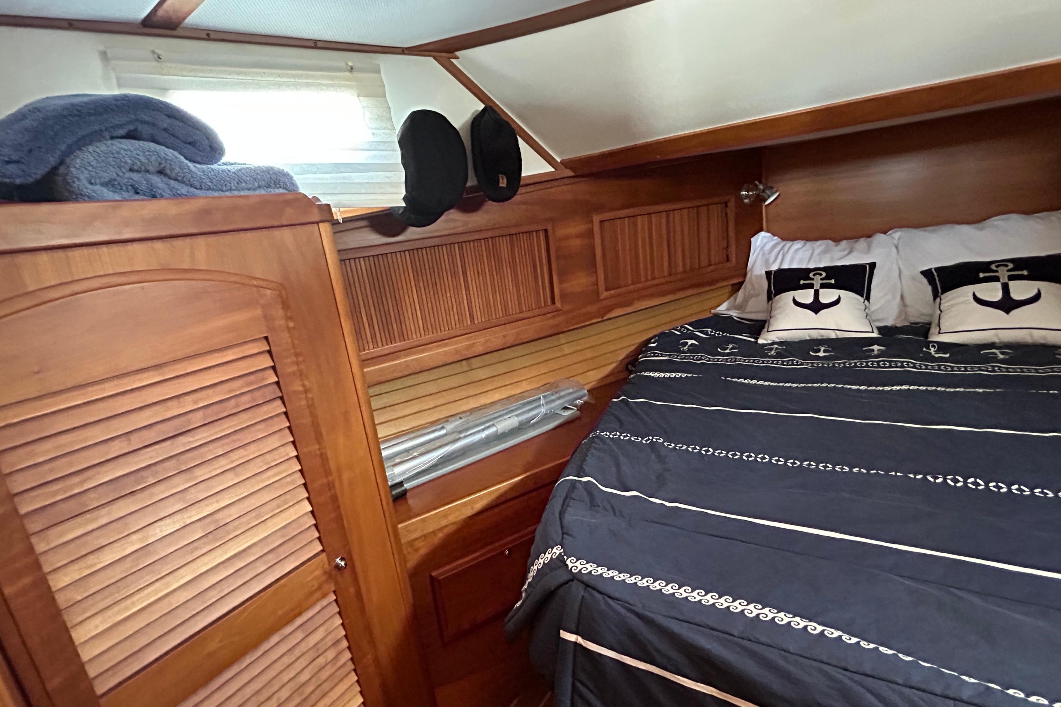 Cozy cabin interior of 2004 Sabre 36 FB yacht with nautical-themed bedding.