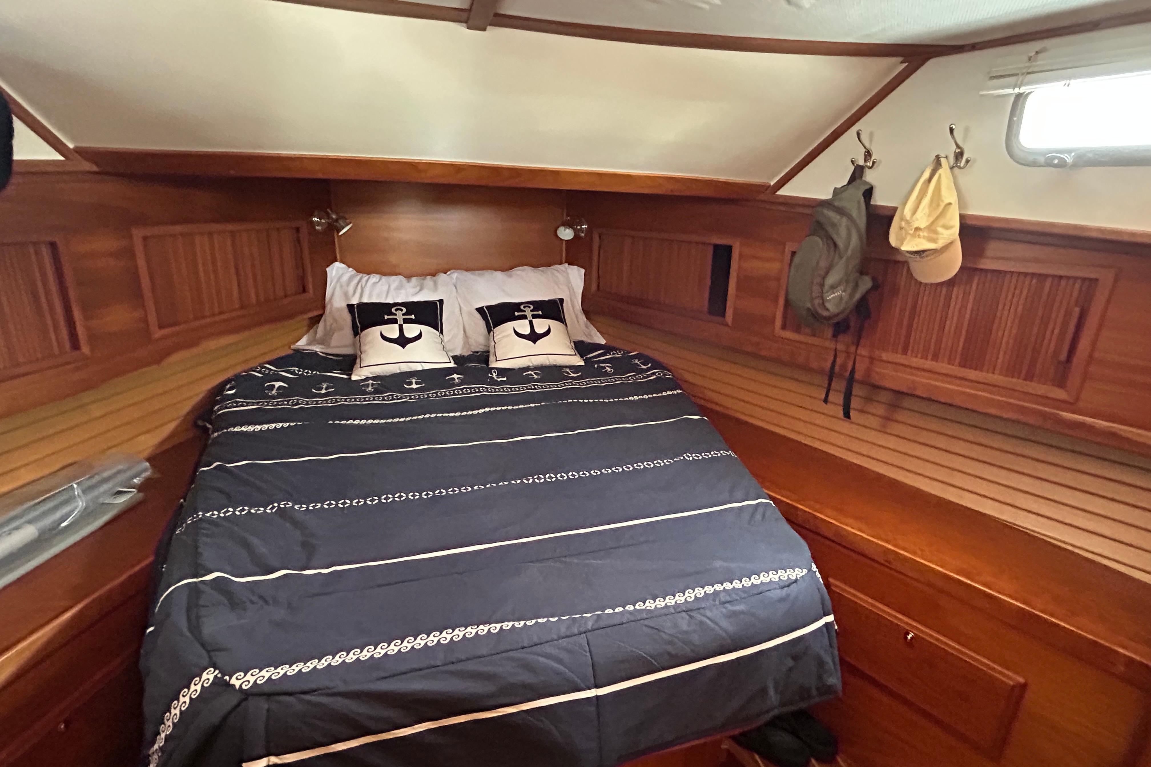 Cozy cabin interior of 2004 Sabre 36 FB yacht with nautical-themed bedding.
