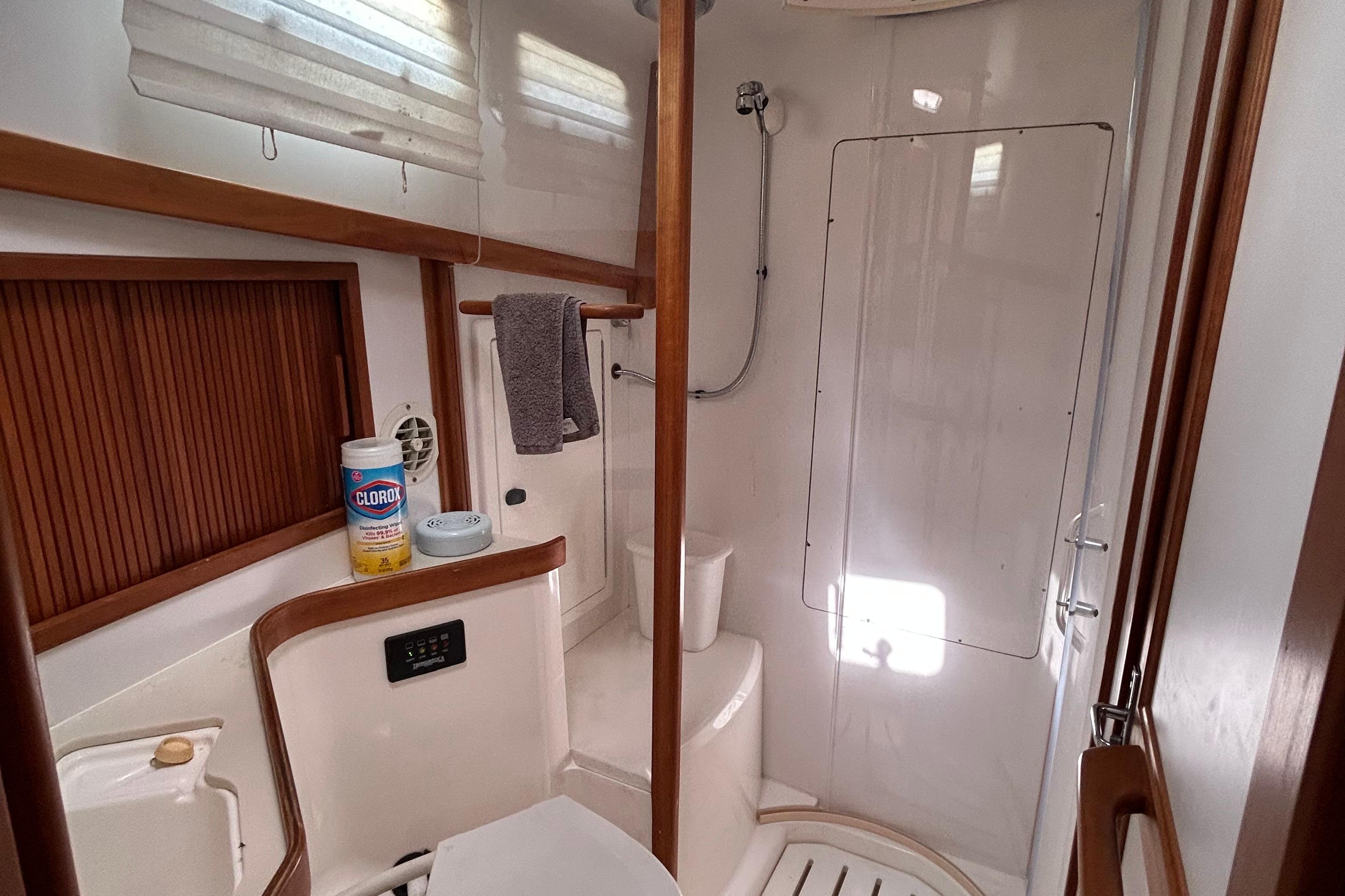 Bathroom interior of 2004 Sabre 36 FB yacht, featuring shower and cleaning supplies.