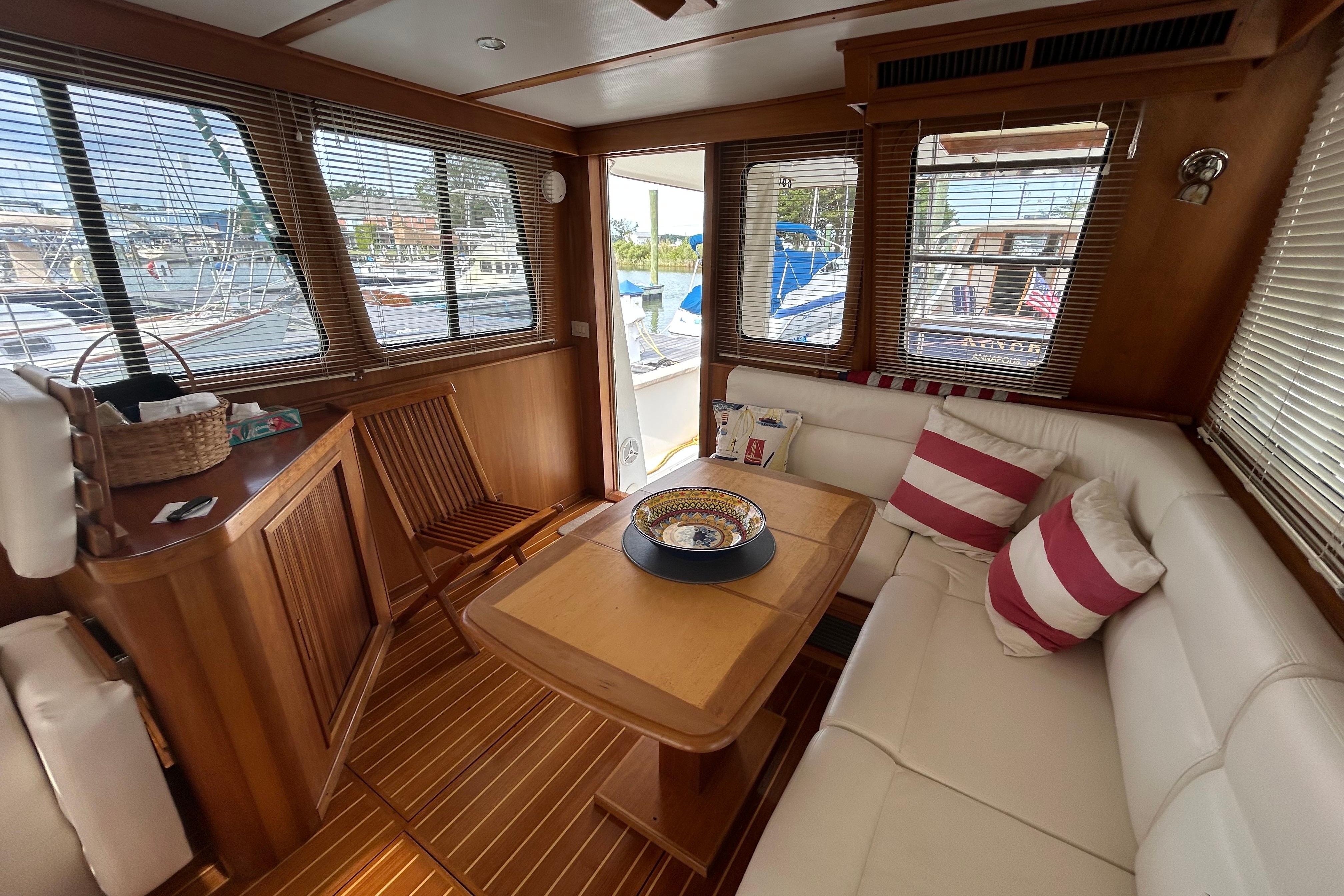 Luxurious 2004 Sabre 36 FB yacht interior with wooden accents and cozy seating area.