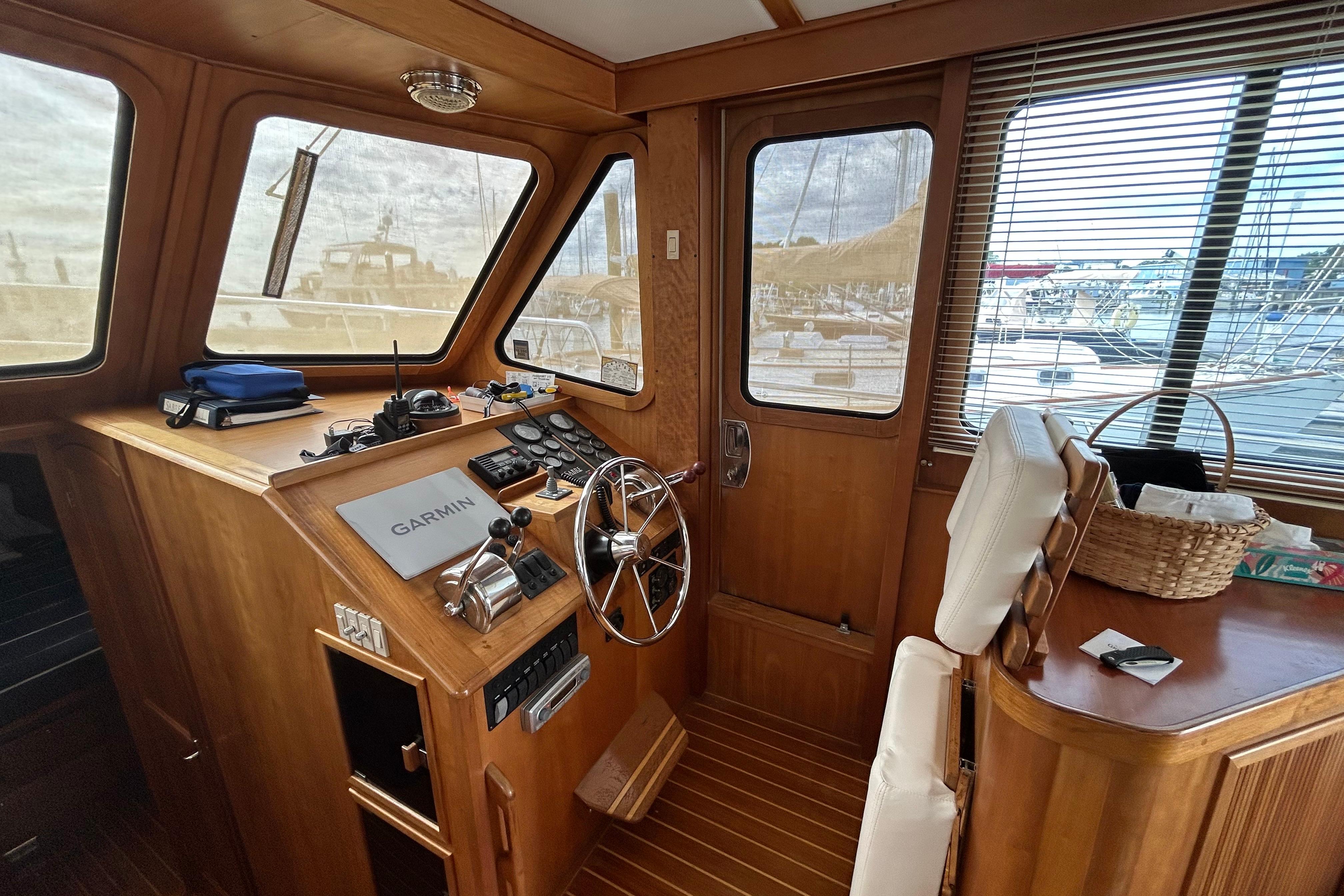 2004 Sabre 36 FB boat interior with wooden helm, steering wheel, and Garmin navigation system.