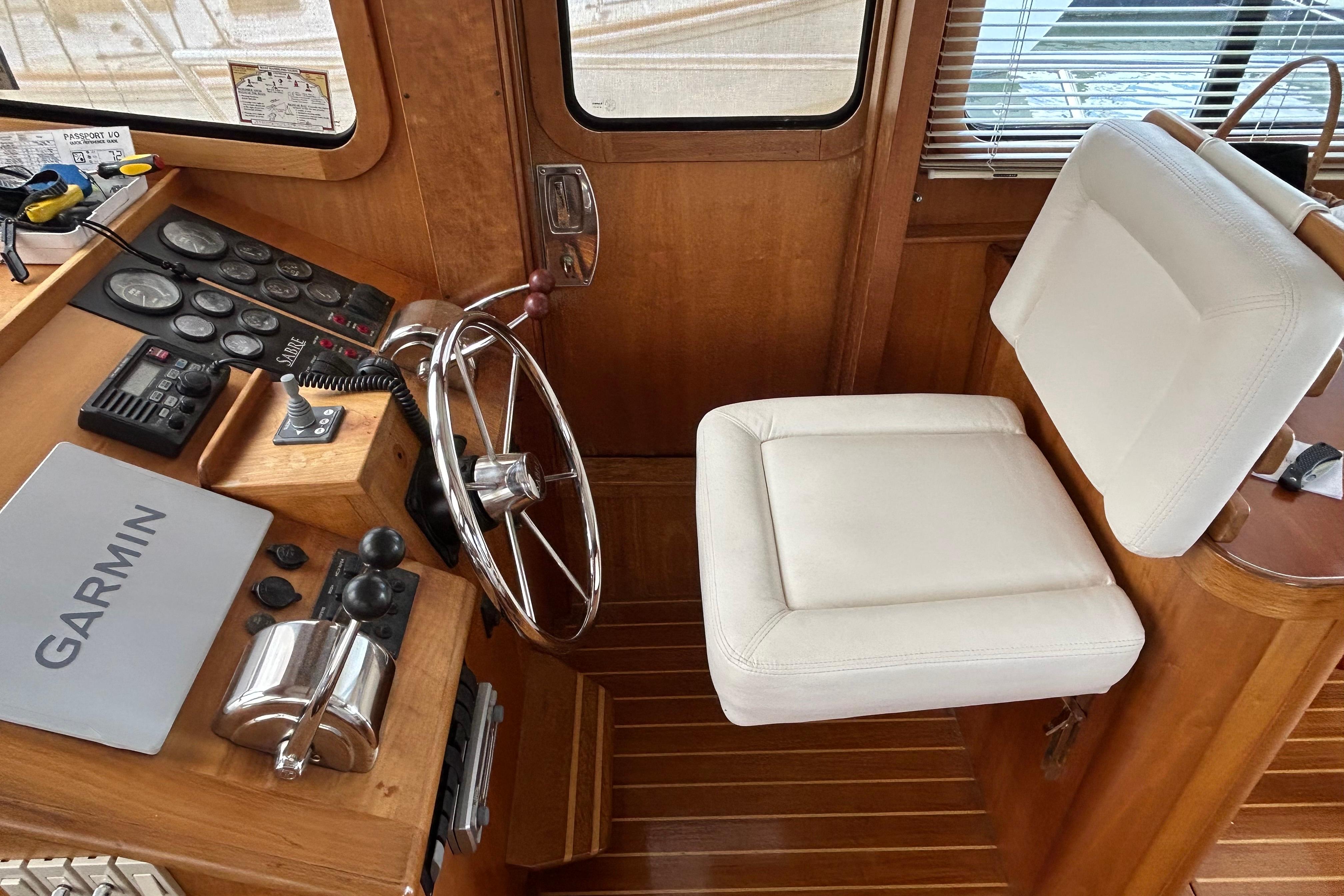 Helm of 2004 Sabre 36 FB yacht with Garmin navigation and white captainu0027s chair.