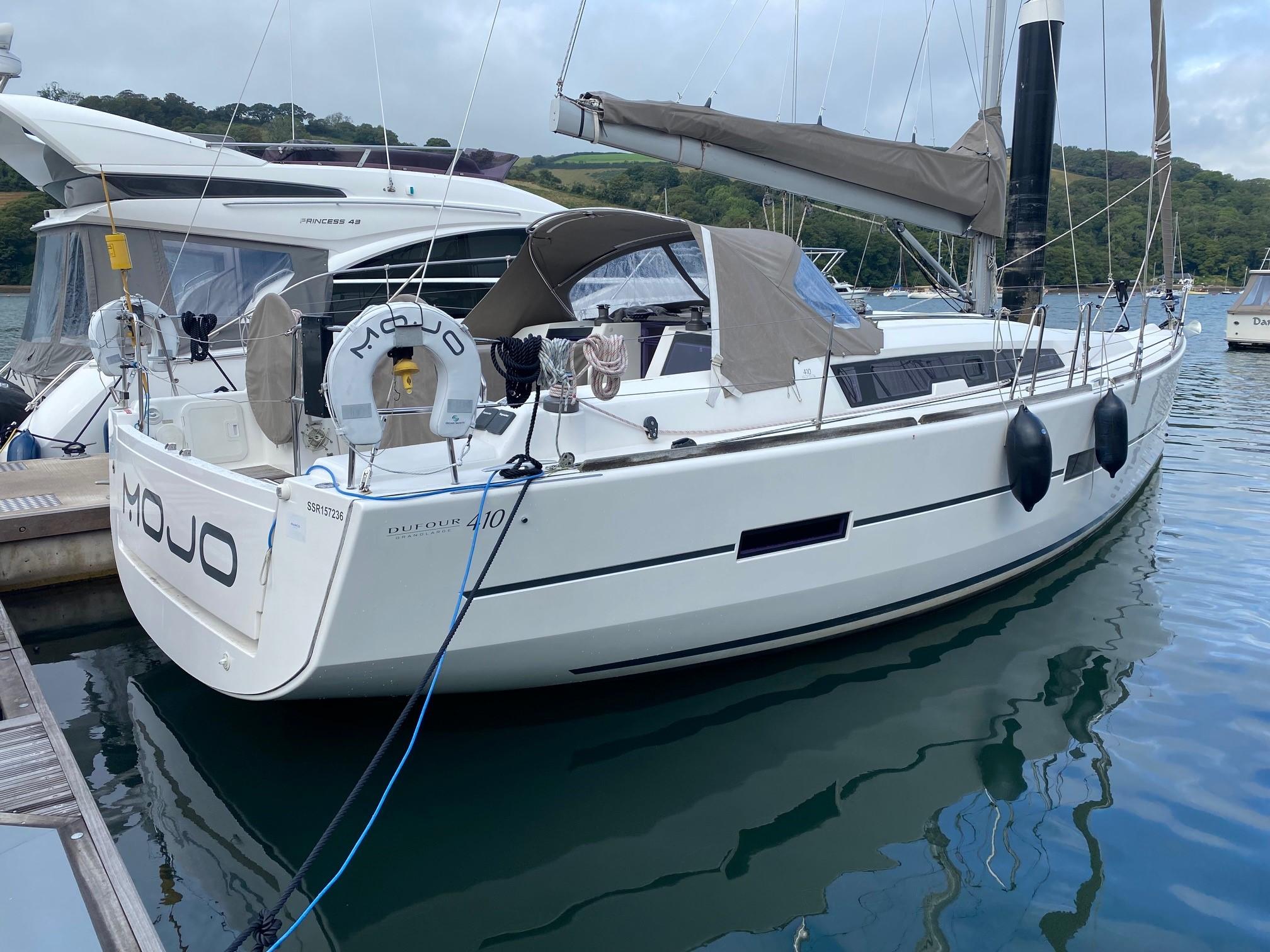 2014 Dufour 410 sailboat docked in a marina, featuring sleek design and modern amenities.
