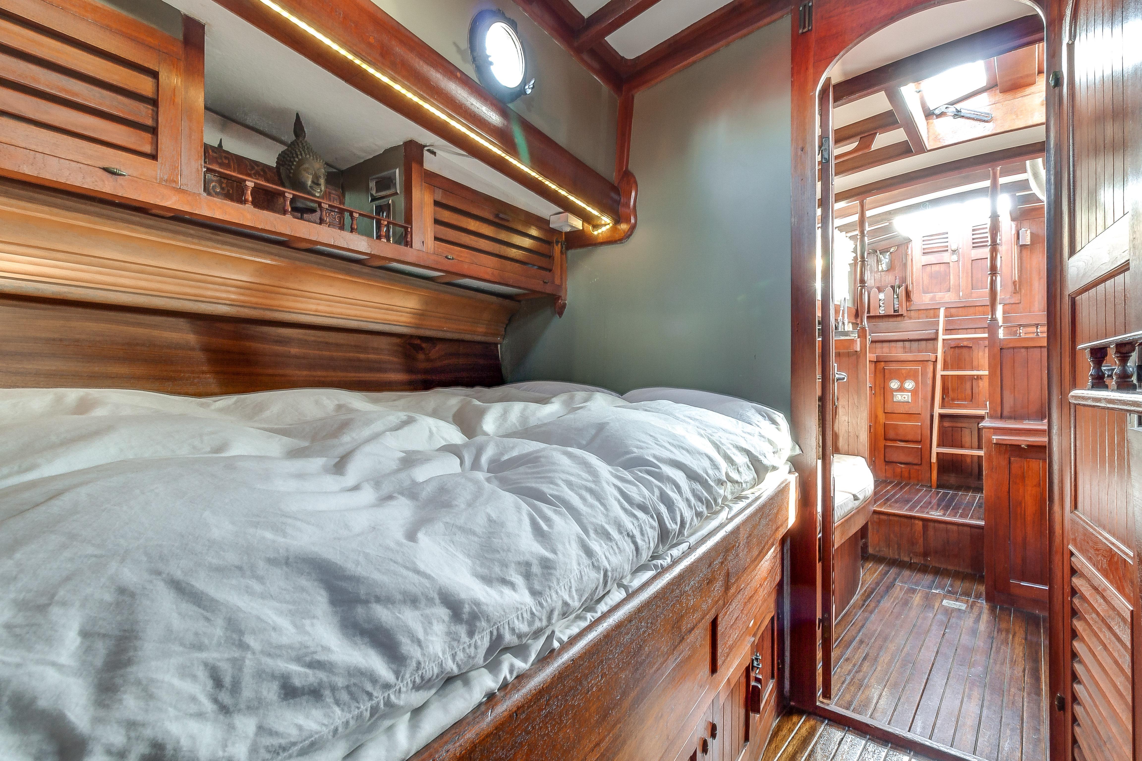 Interior of 1971 Formosa 41 sailboat with wooden cabin and cozy bed.