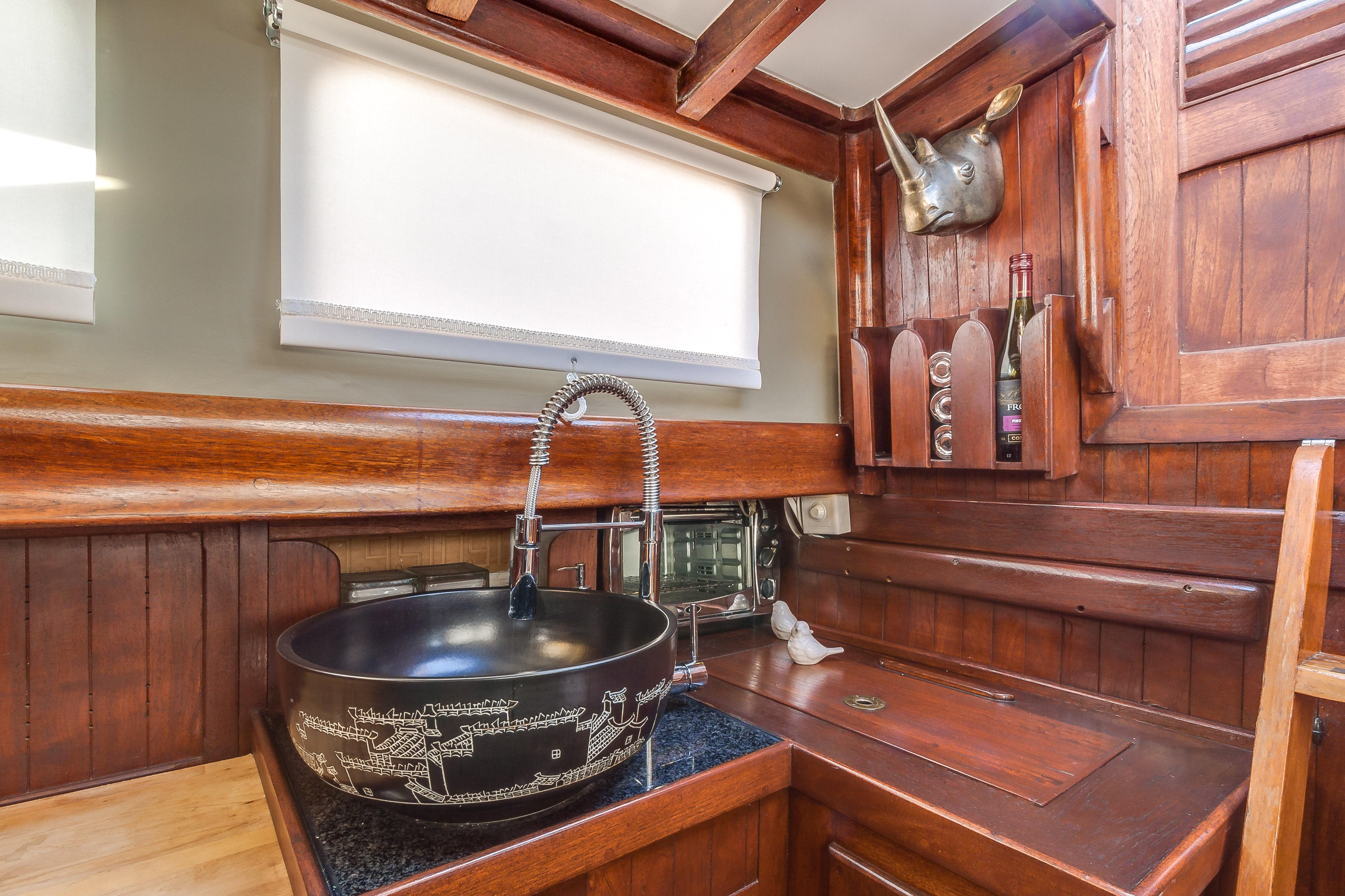 Vintage 1971 Formosa 41 yacht interior with wooden cabinetry and decorative sink.